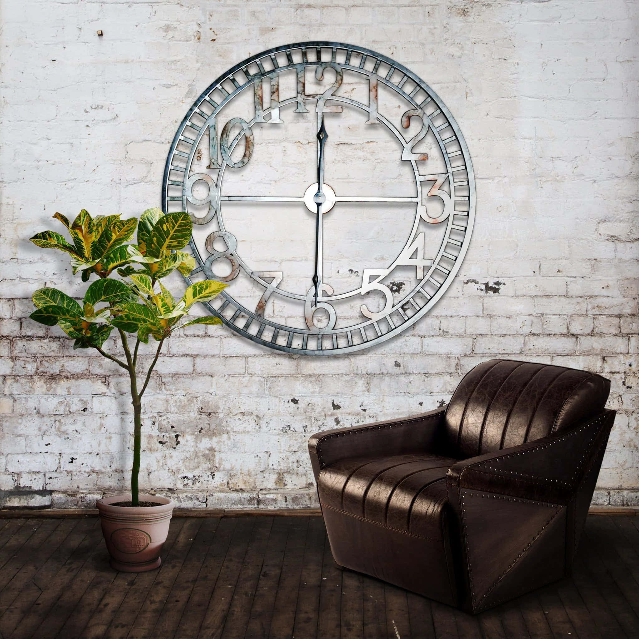 Wall Clock 桌布 壁紙 — 一個大型工業風格時鐘掛在風化的白色磚牆上，下方是深色皮革扶手椅和盆栽植物，營造出質樸的房間氛圍。
