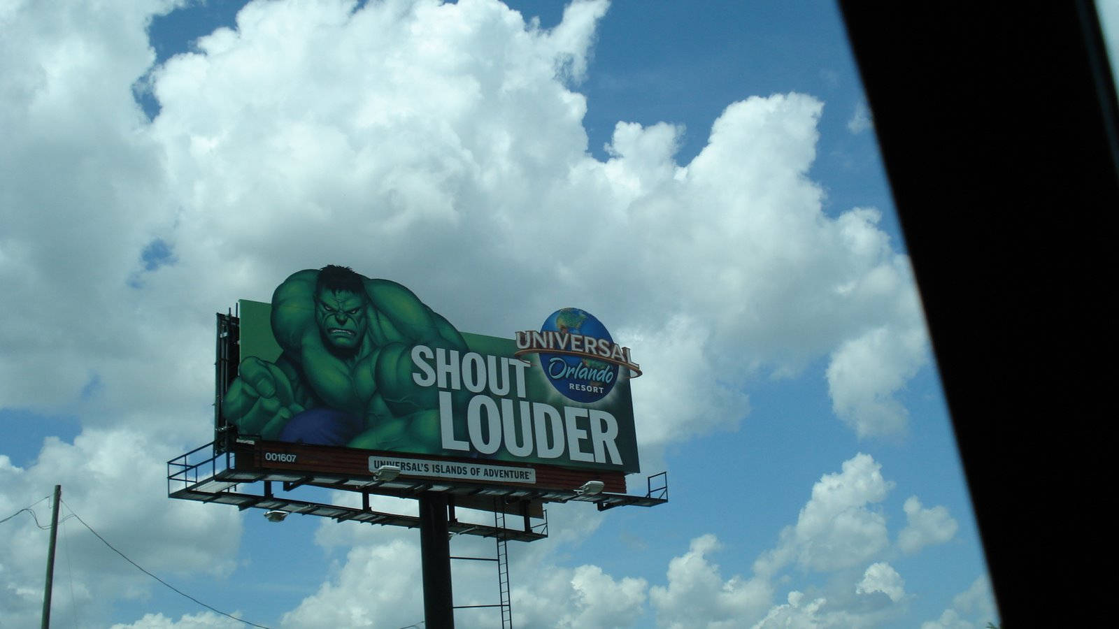 Universal 桌布 壁紙 — 一個大型廣告牌，上面有綠色的浩克和「SHOUT LOUDER」文字，背景是局部多雲的藍天。