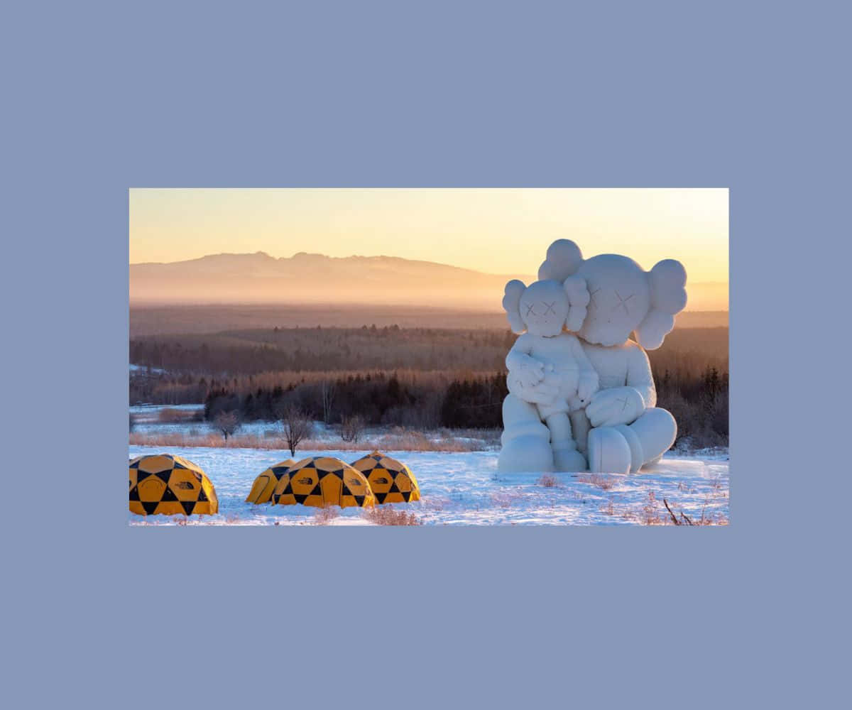 Kaws Holiday 桌布 壁紙 — 一個大型白色KAWS雕塑，描繪兩個擁抱的人物，坐落在雪地中，夕陽下附近有黃色晶洞，遠山沐浴在金色光芒中。