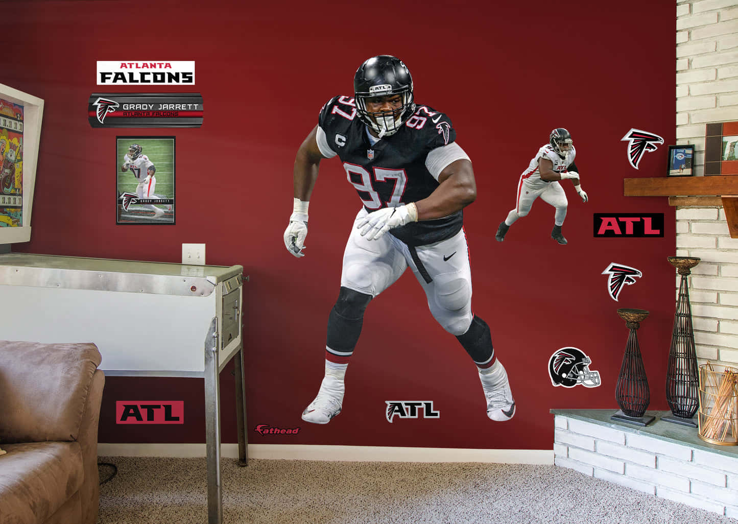 足球 桌布 壁紙 — 一個大型的 Grady Jarrett 亞特蘭大獵鷹足球員牆貼主導了一個帶有球隊標誌和壁爐的紅色房間。