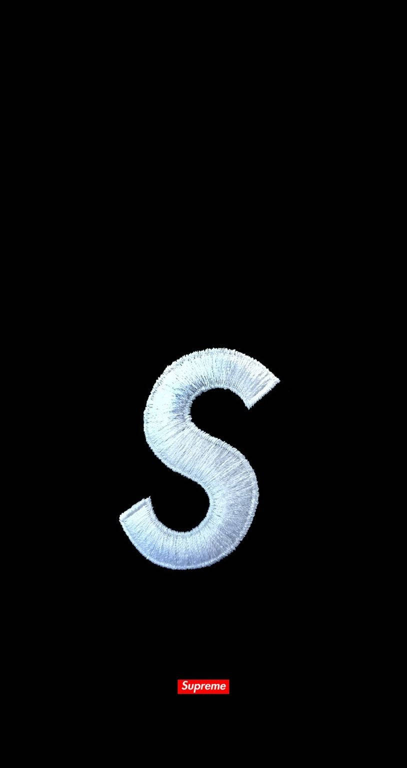 supreme 桌布 壁紙 — 一個大型紋理銀色刺繡字母S居中於黑色背景上，底部有一個細小的紅色Supreme標誌。