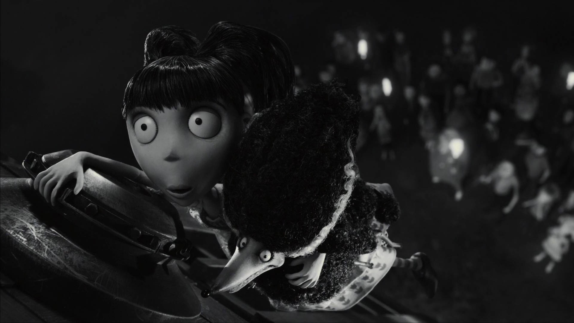 Frankenweenie 桌布 壁紙 — 一個大眼動畫女孩和一個毛茸茸的生物從壁架邊緣窺視著一群發光的人物，場景為黑暗單色。