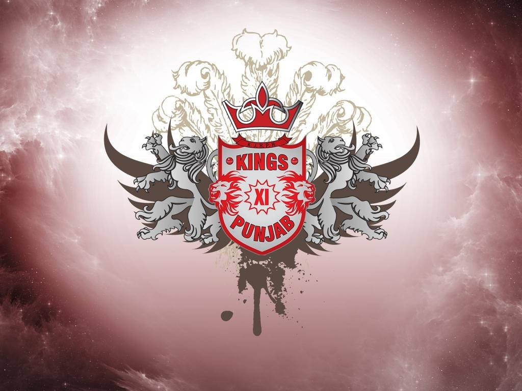 punjab kings 桌布 壁紙 — 一個大膽的Kings XI Punjab運動標誌，帶有戴冠的獅子和翅膀，背景是宇宙粉紅色和白色星雲。