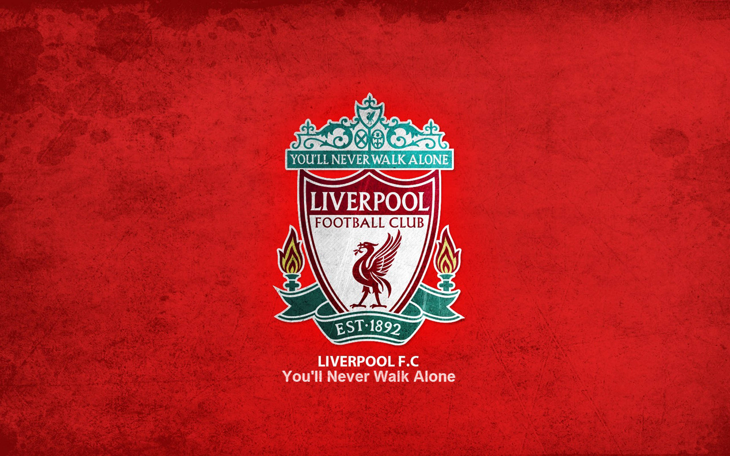 Liverpool Fc 桌布 壁紙 — 一個大膽的利物浦足球俱樂部徽章，居中於帶紋理的紅色背景上，附有俱樂部格言和成立年份。