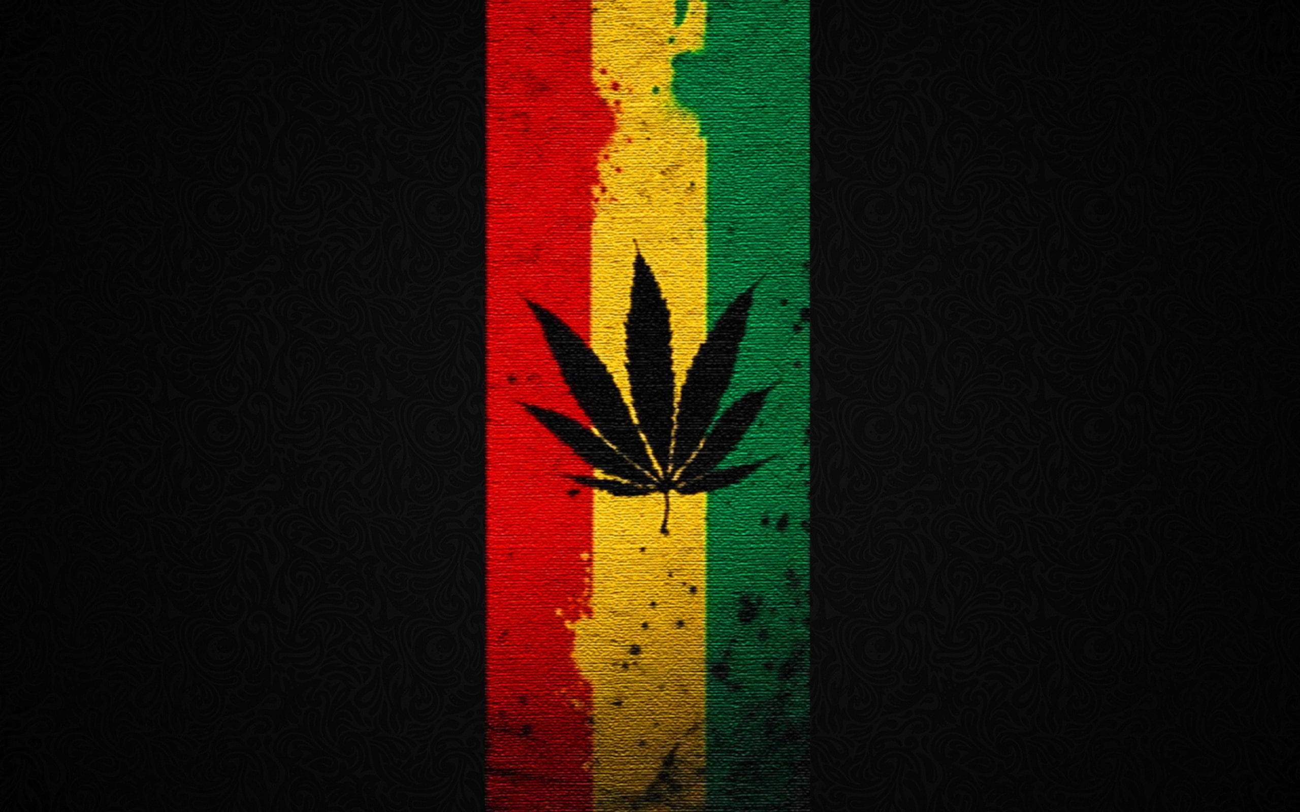 大麻 桌布 壁紙 — 一個大膽的大麻葉剪影，居中在一個有紋理的垂直條紋上，條紋顏色為紅、黃、綠，背景為深色。
