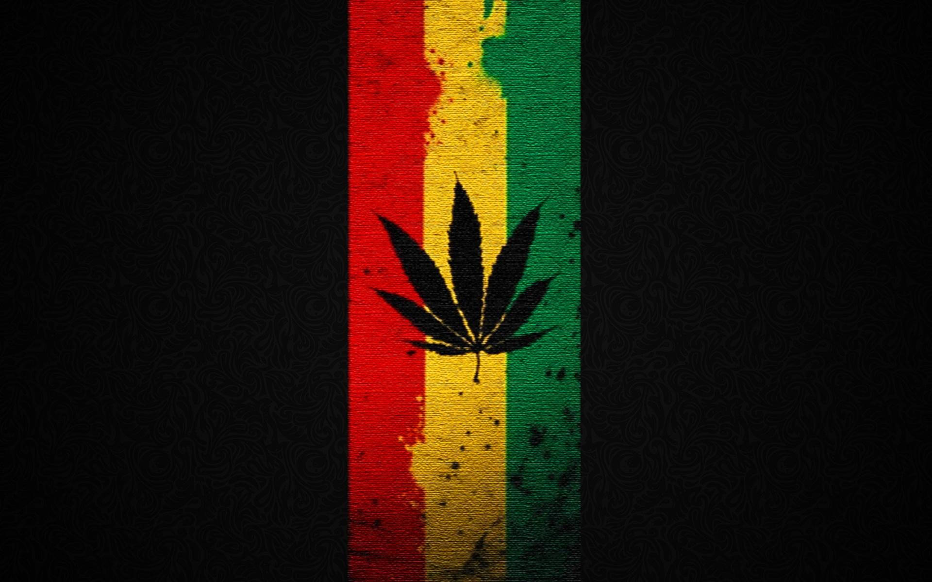 Reggae 桌布 壁紙 — 一個大膽的大麻葉剪影，居中於一條磨損的垂直條紋（紅、黃、綠），背景為深色紋理。