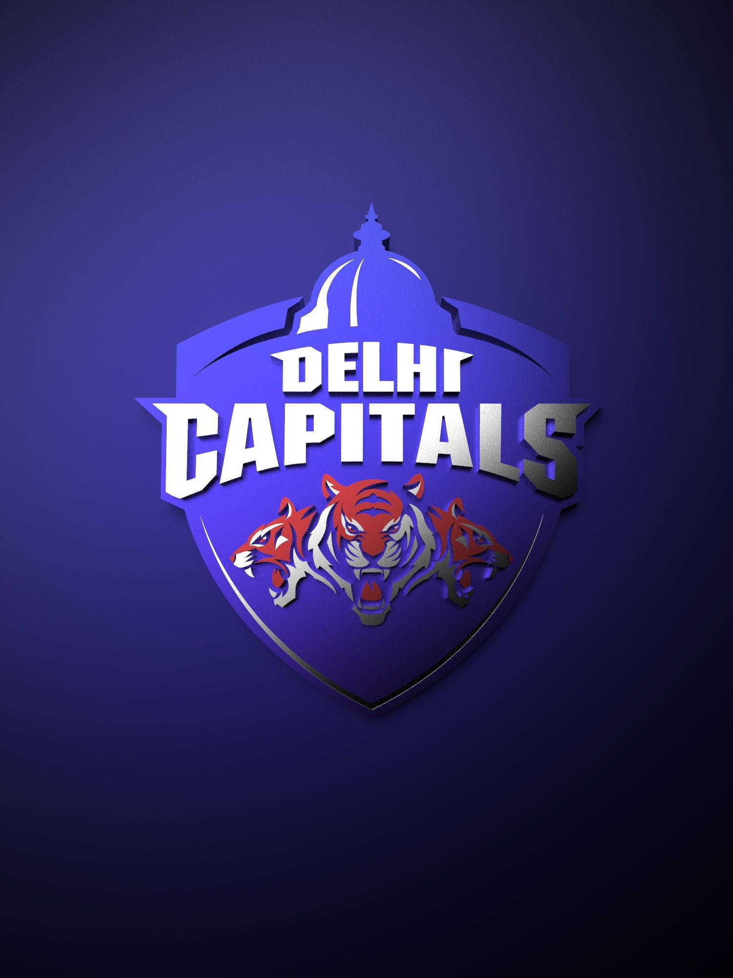 Delhi Capitals 桌布 壁紙 — 一個大膽的德里首都隊標誌，在深藍色漸變背景上，圓頂下有三隻咆哮的老虎。
