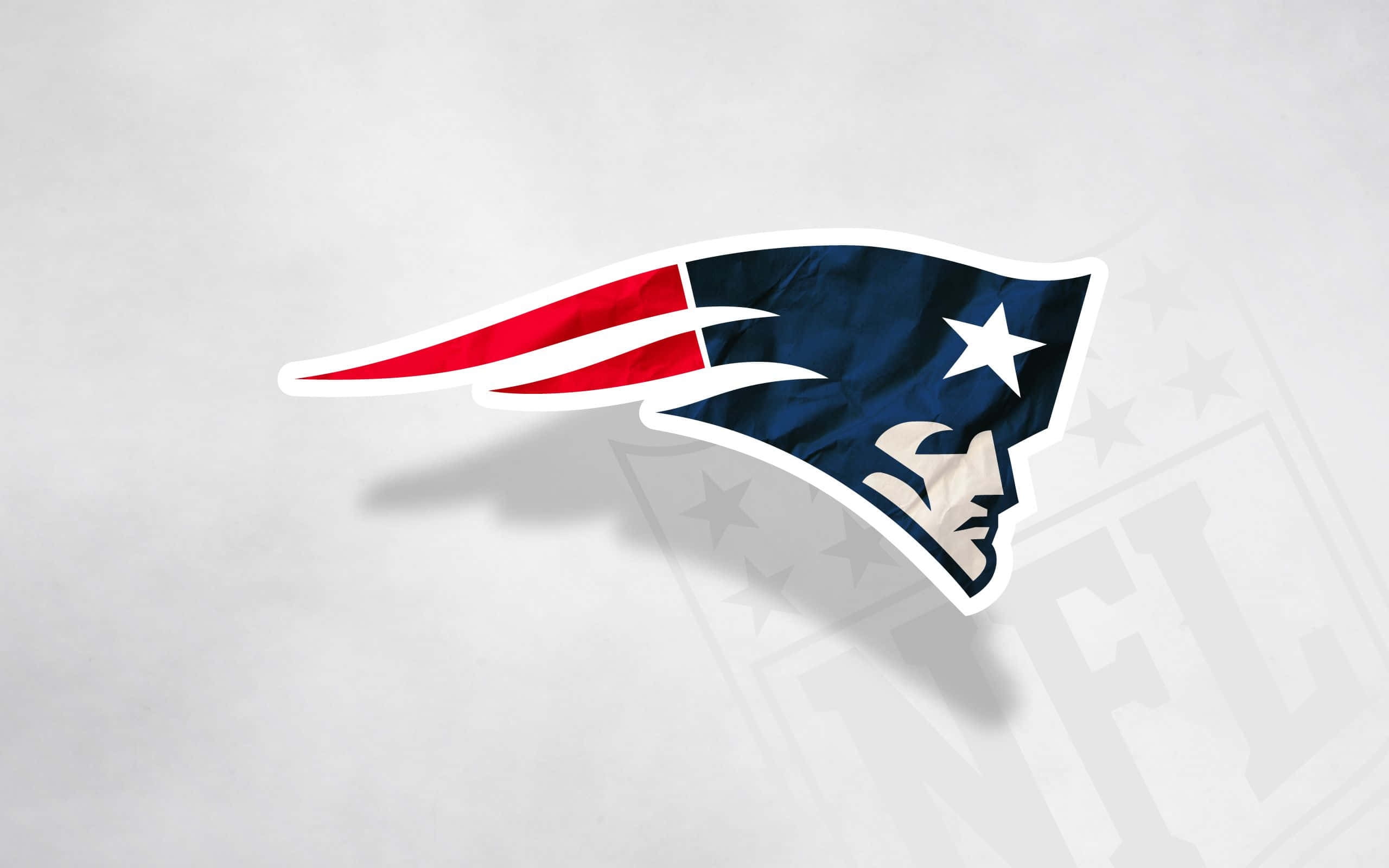 Patriots 桌布 壁紙 — 一個大膽的新英格蘭愛國者標誌，採用紅、白、藍三色，在帶有紋理的灰色背景上投射出柔和的陰影。