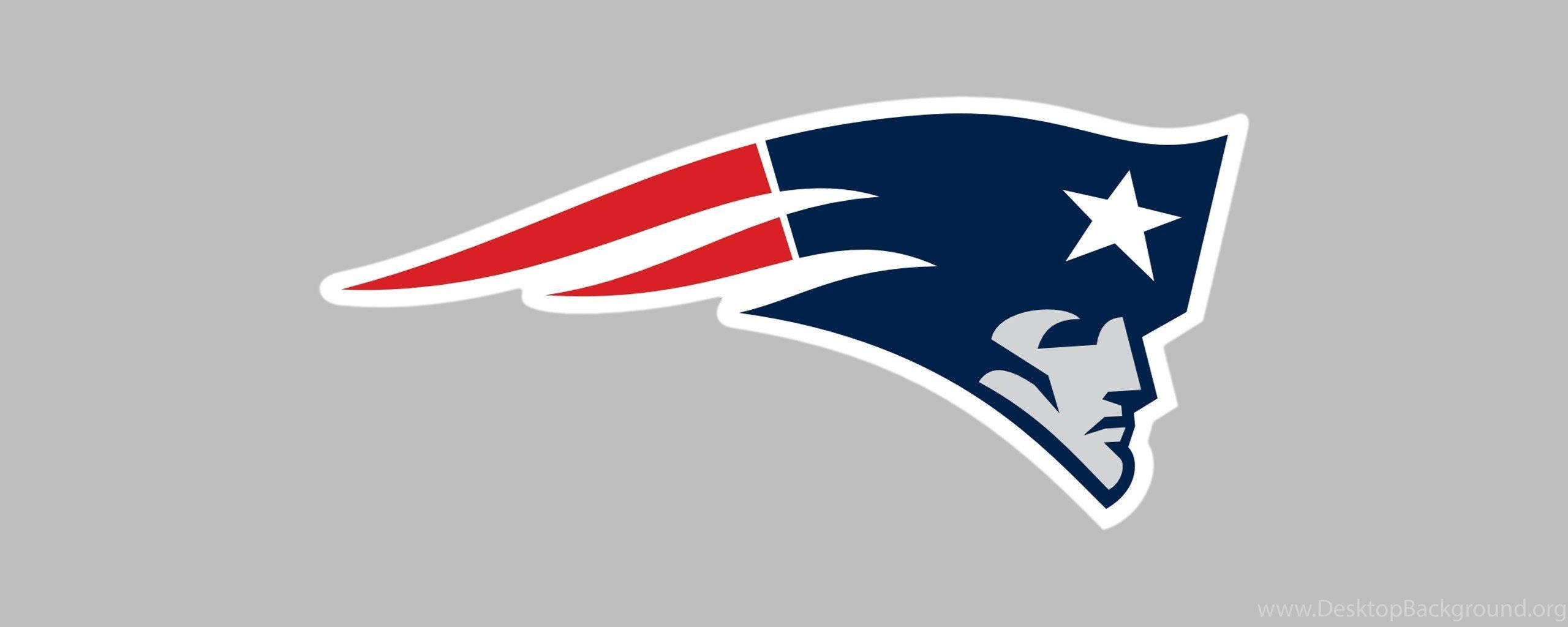 NFL Teams 桌布 壁紙 — 一個大膽的新英格蘭愛國者隊標誌，包含藍色頭盔、白色星星和紅白條紋，背景為灰色。