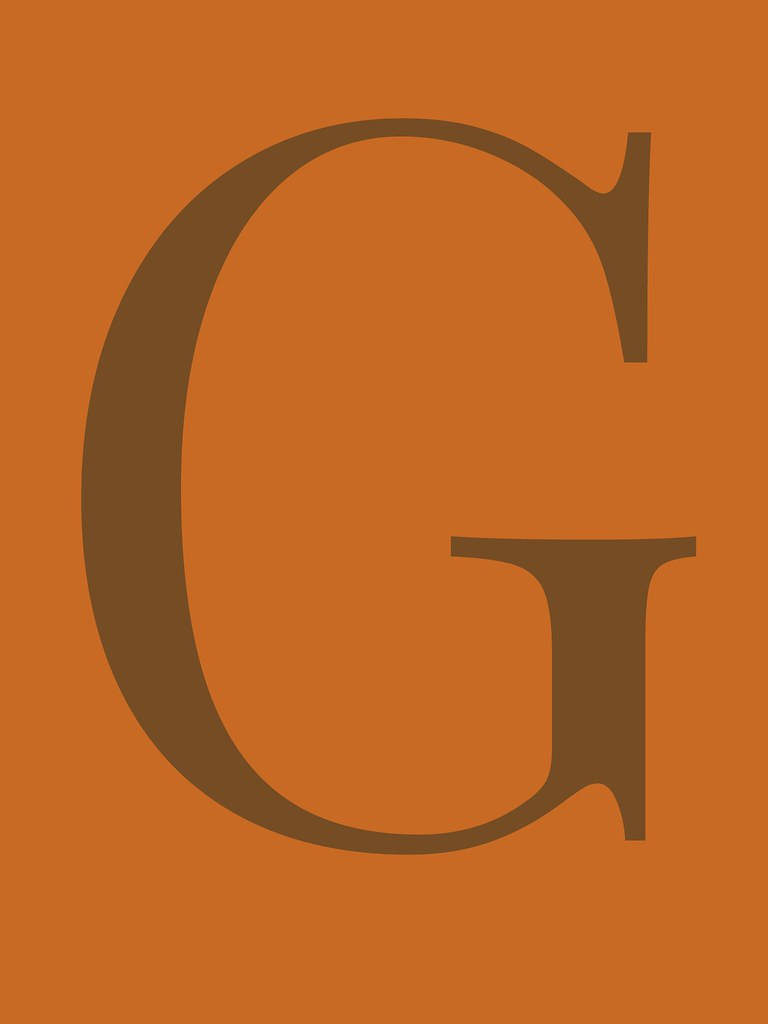 g 桌布 壁紙 — 一個大膽的棕色字母G居中於純色陶土橙色背景上。
