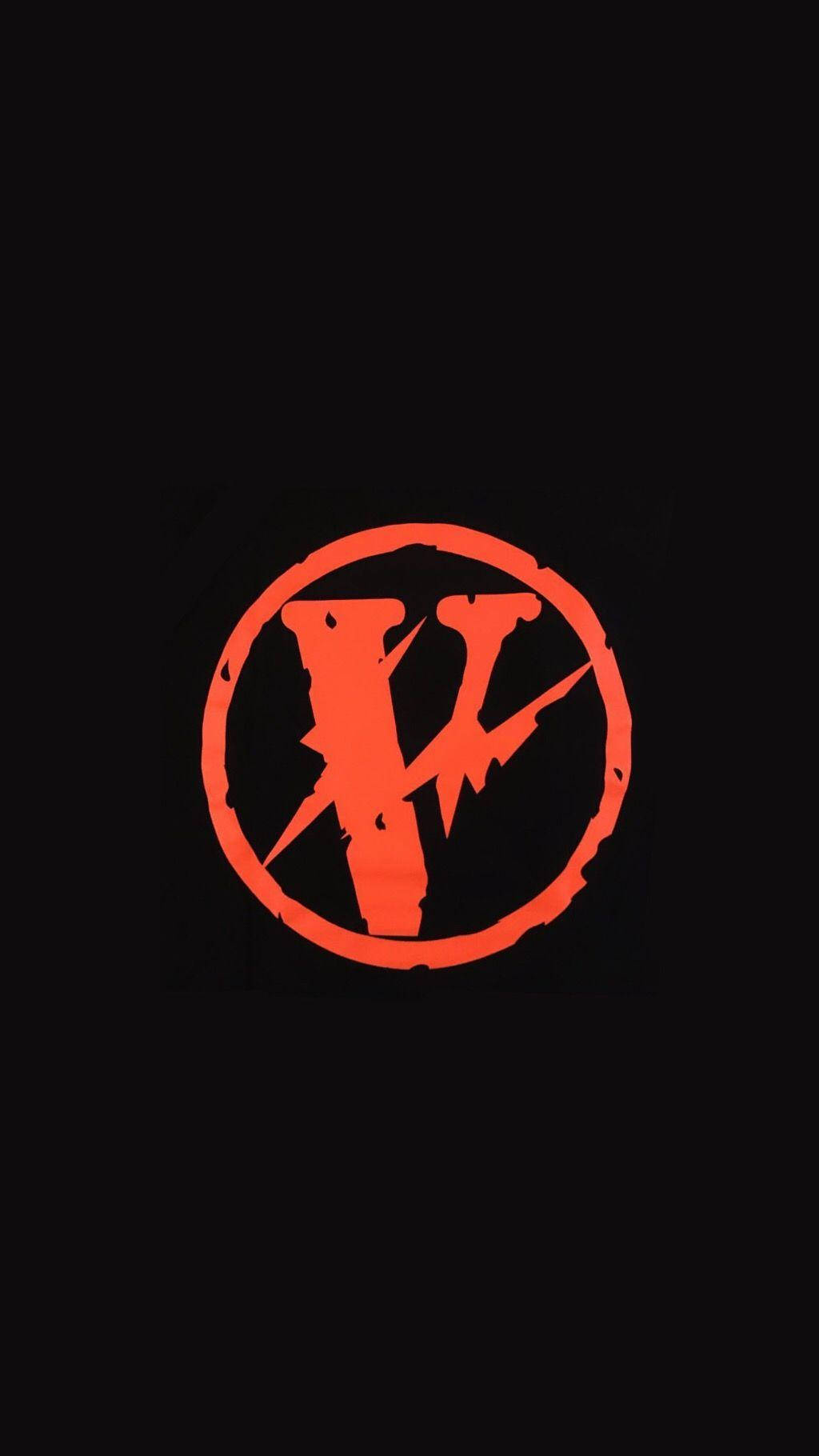 Vlone 桌布 壁紙 — 一個大膽的橙色風格化V符號在圓圈內，在純黑色背景上發光。