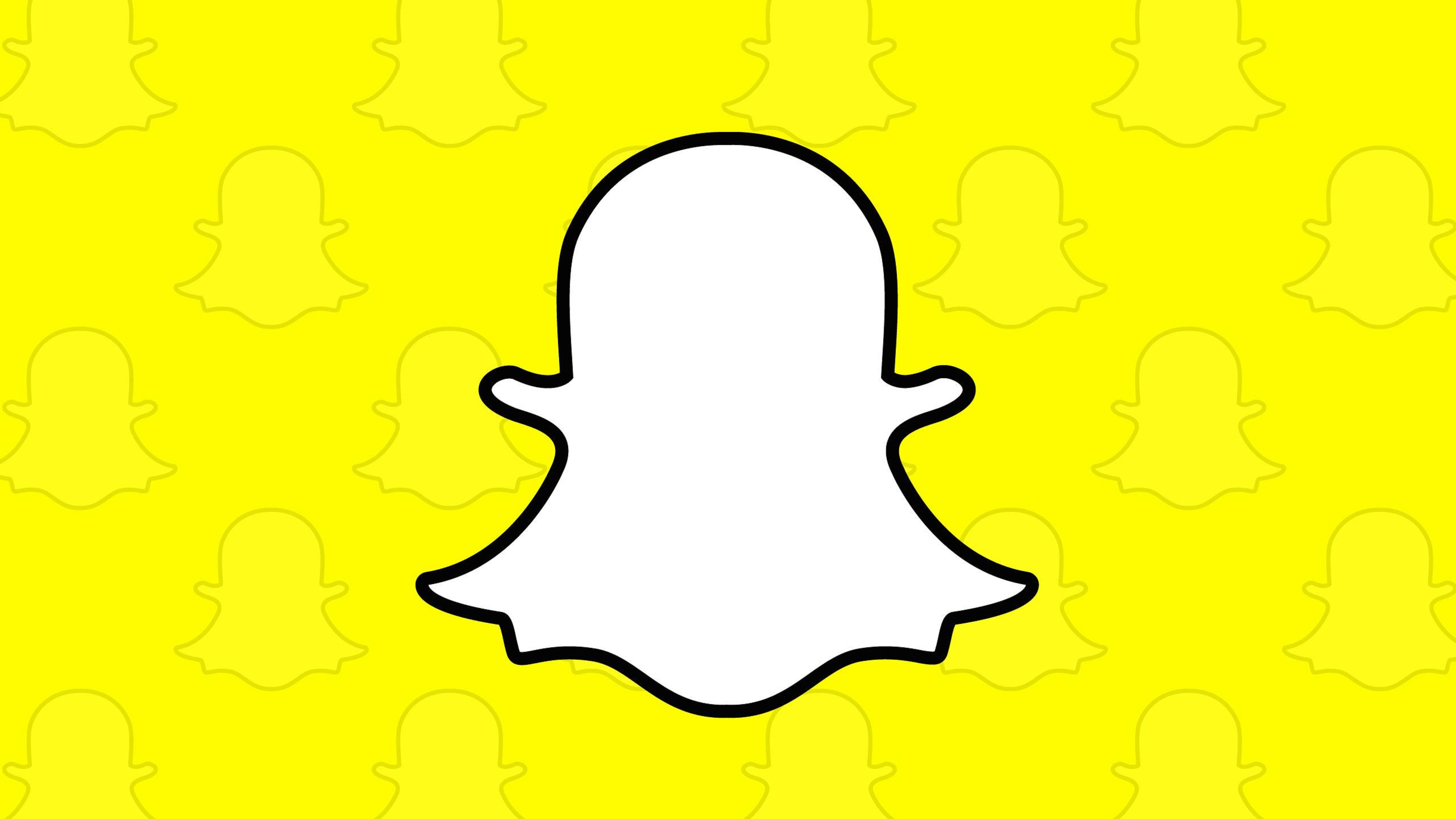 Snapchat 桌布 壁紙 — 一個大膽的白色Snapchat鬼魂標誌，帶有黑色輪廓，居中在充滿活力的黃色背景上，帶有微弱的重複鬼魂圖案。
