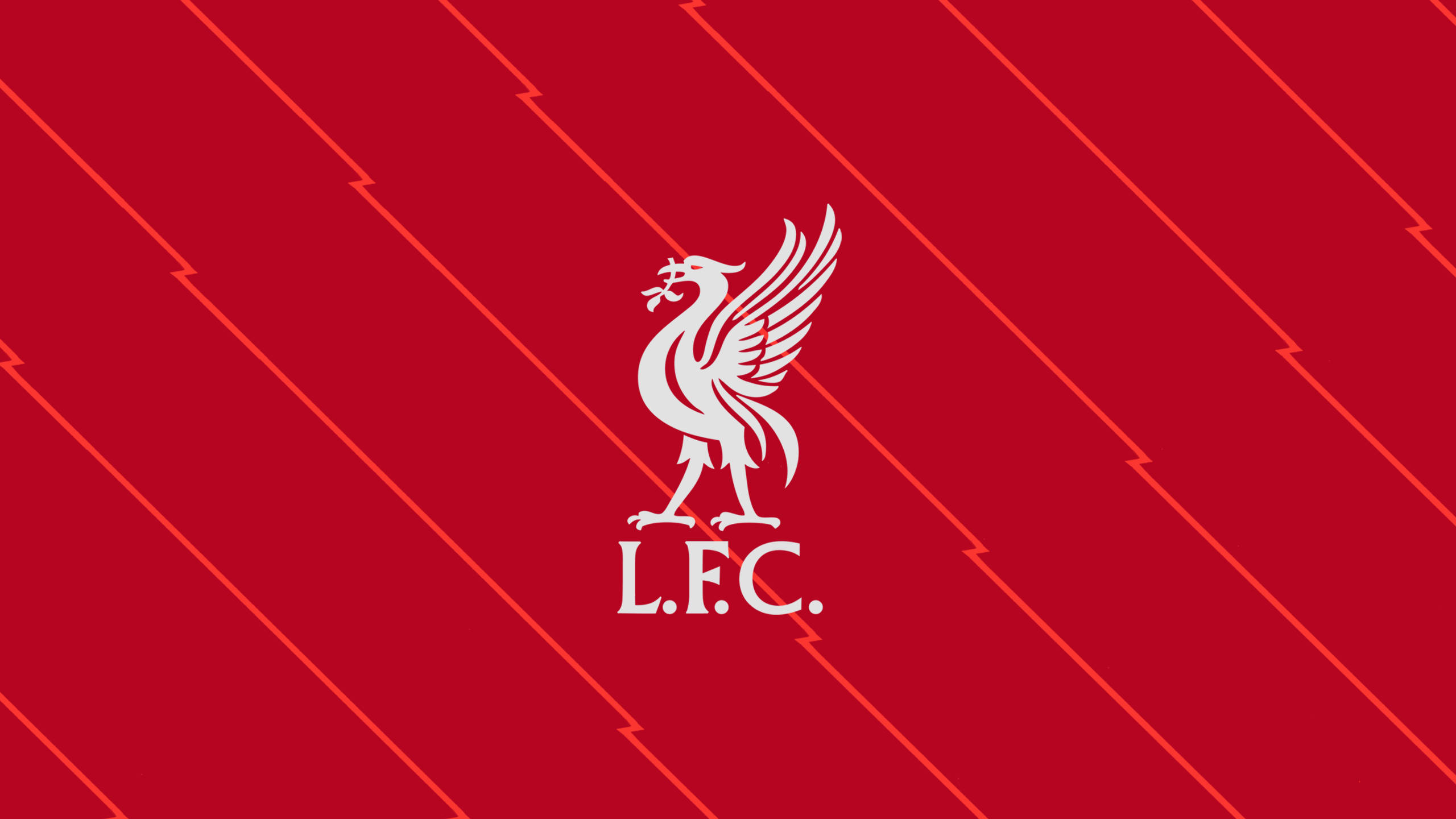 Liverpool Fc 桌布 壁紙 — 一個大膽的白色利物浦足球會徽章，中央有一隻鳥和縮寫，置於充滿活力的紅色背景上，帶有對角閃電條紋。