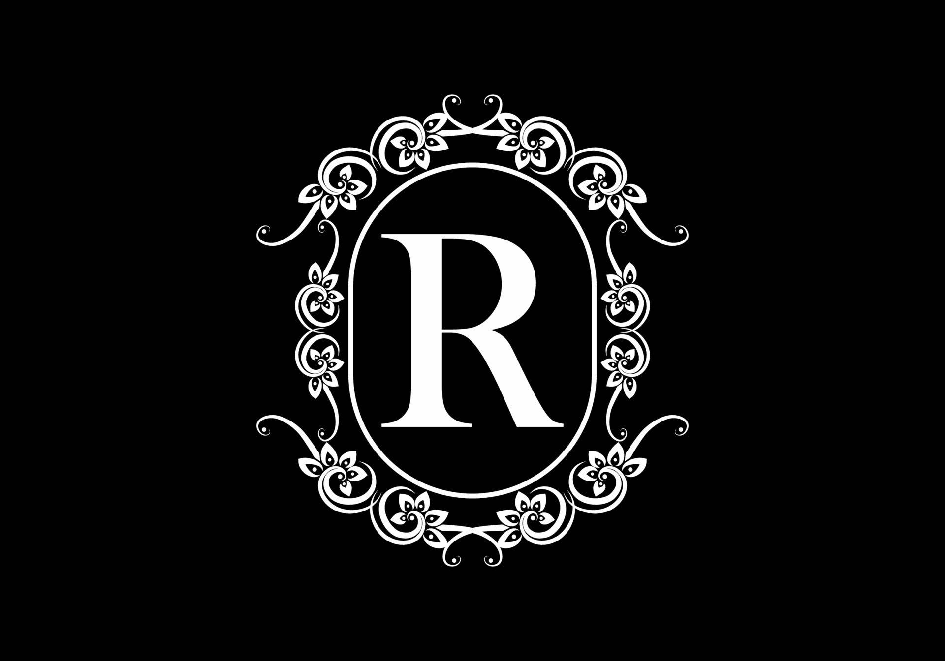 R 桌布 壁紙 — 一個大膽的白色字母R，在帶有花卉漩渦的華麗圓形框架中，在純黑色背景上脫穎而出。