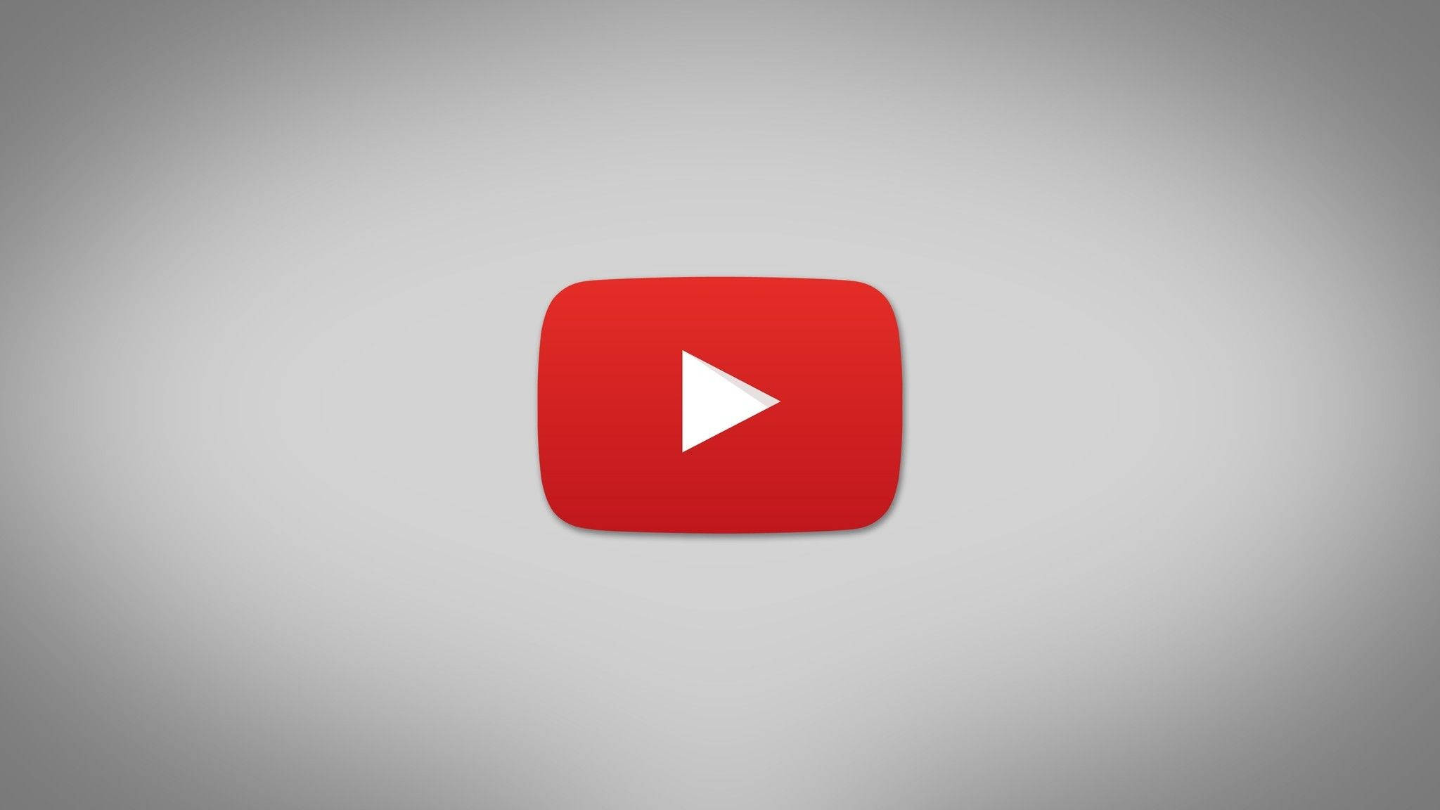 YouTube 桌布 壁紙 — 一個大膽的紅色 YouTube 播放按鈕圖示，居中於柔和的灰色漸變背景上。