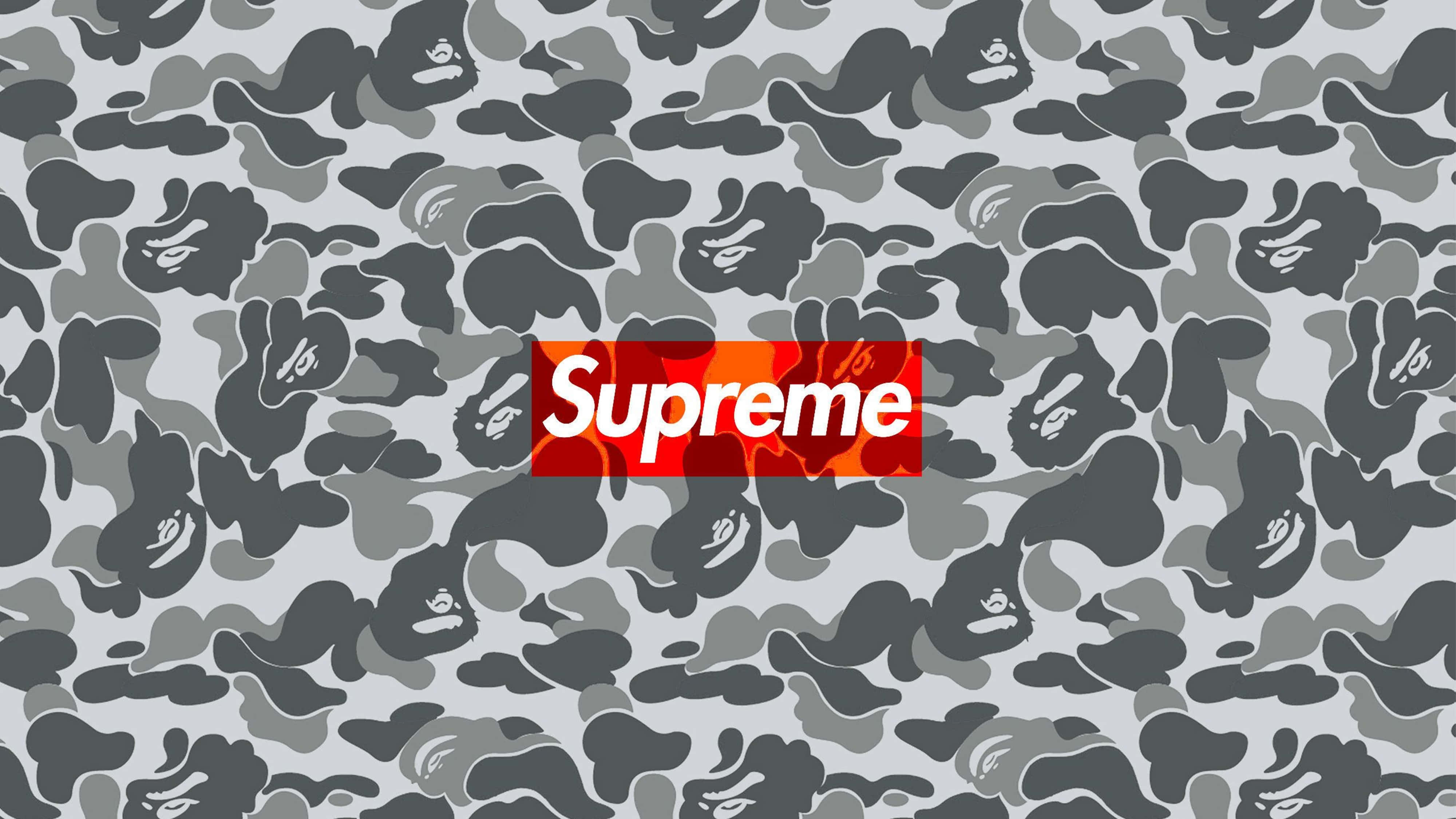 supreme aesthetic 桌布 壁紙 — 一個大膽的紅色Supreme標誌居中於灰色迷彩圖案上，帶有重複的猿頭剪影。