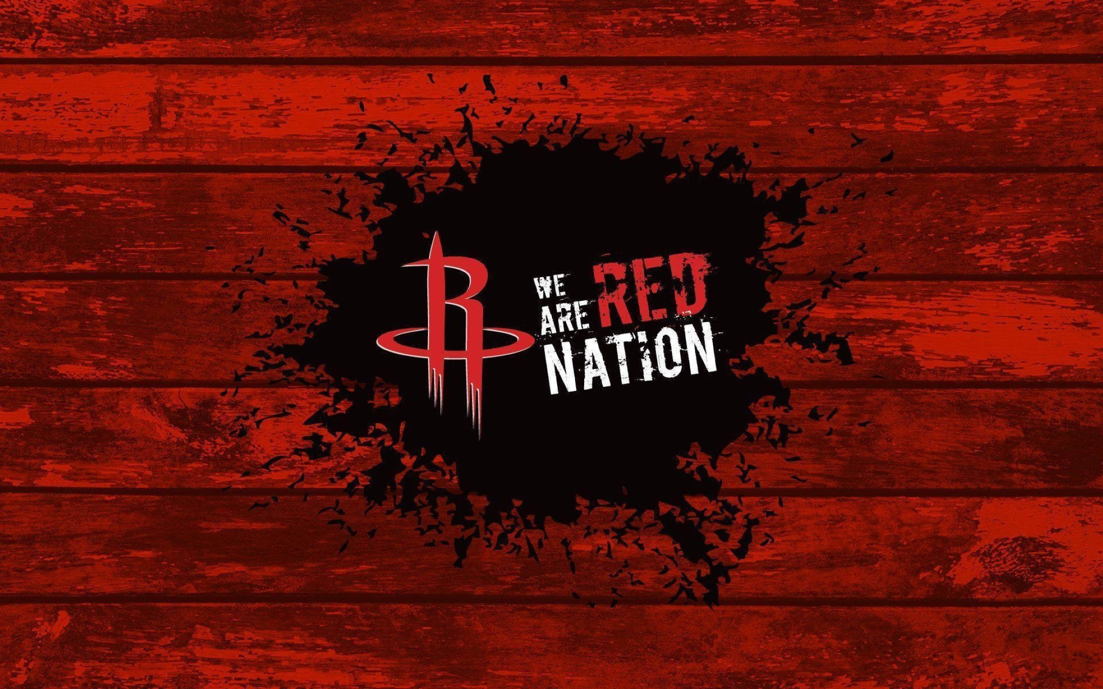 Houston Rockets 桌布 壁紙 — 一個大膽的紅色休士頓火箭隊標誌和「We Are Red Nation」文字從黑色墨水飛濺中迸發出來，背景是風化的紅色木板。
