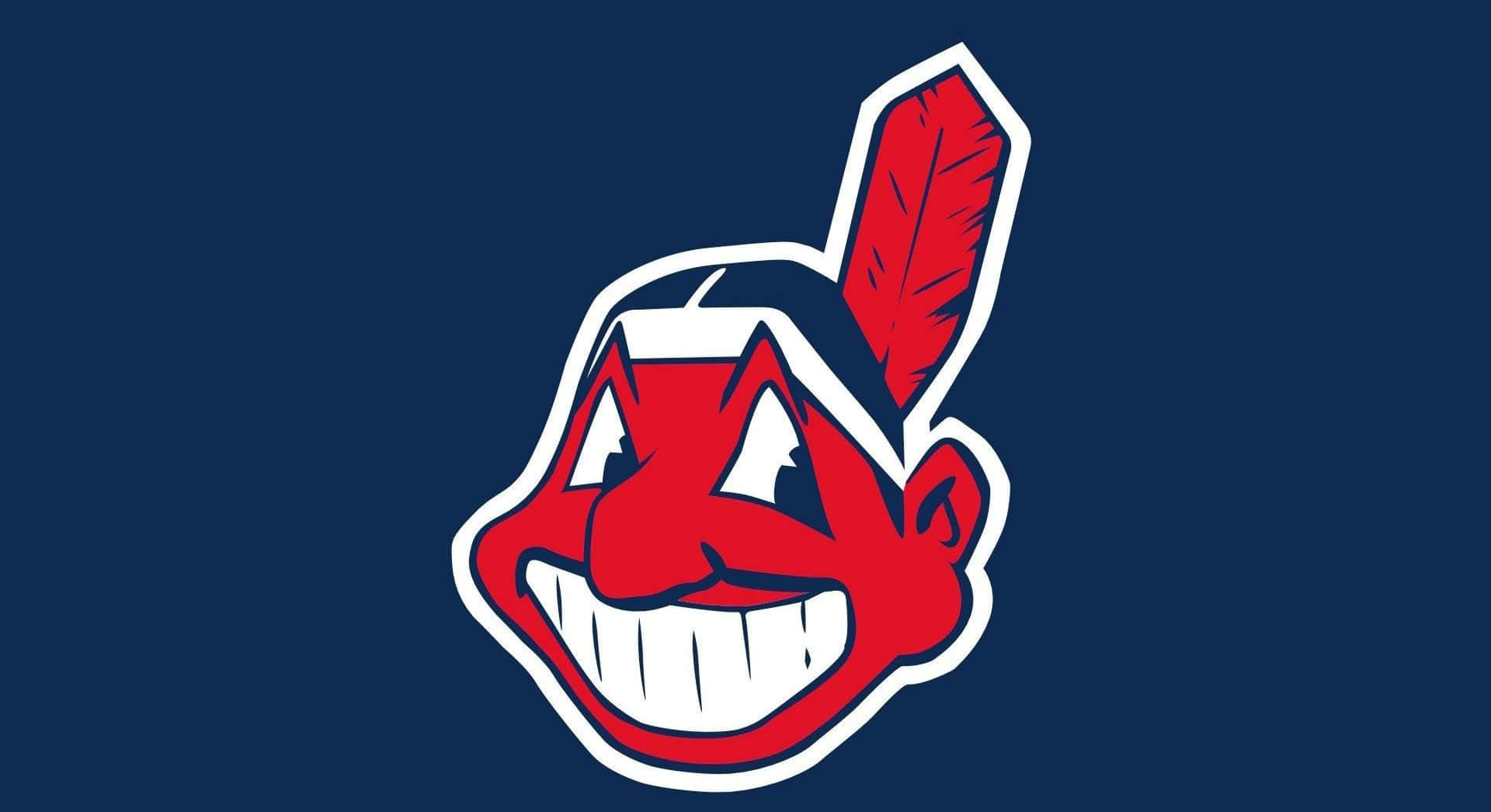 MLB Teams 桌布 壁紙 — 一個大膽的紅色卡通美洲原住民吉祥物頭像，帶有羽毛和寬闊的笑容，背景為深藍色。