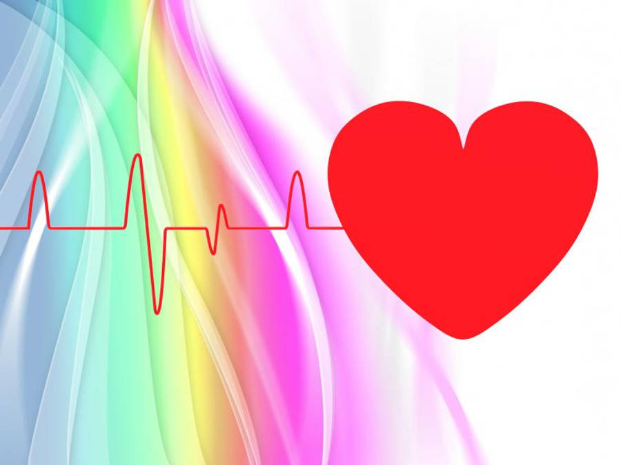 Heartbeat 桌布 壁紙 — 一個大膽的紅色心臟隨著心跳線在流動的彩虹漸變背景上跳動。