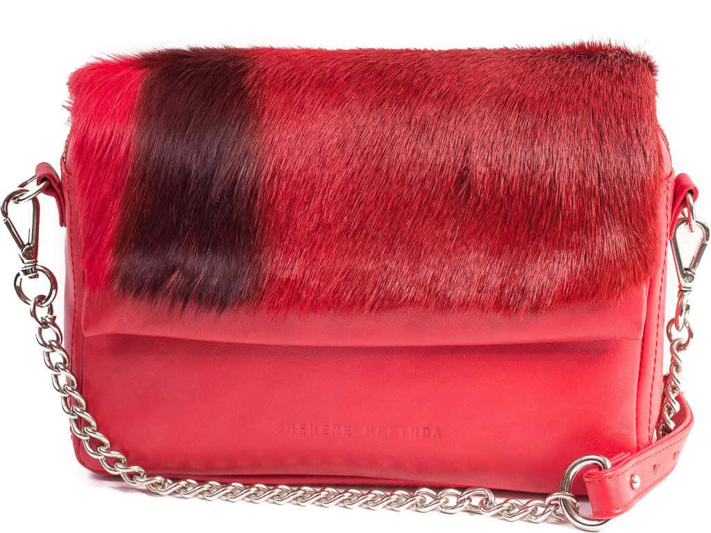 Red Handbag 桌布 壁紙 — 一個大膽的紅色手提包，配有仿皮草翻蓋和銀色鏈條肩帶，背景為白色。