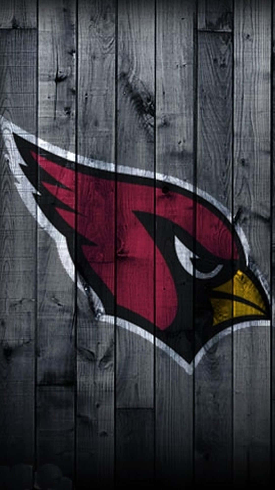 Arizona Cardinals 桌布 壁紙 — 一個大膽的紅色紅雀標誌，帶有白色和黃色點綴，在風化的灰色木板背景上格外醒目。