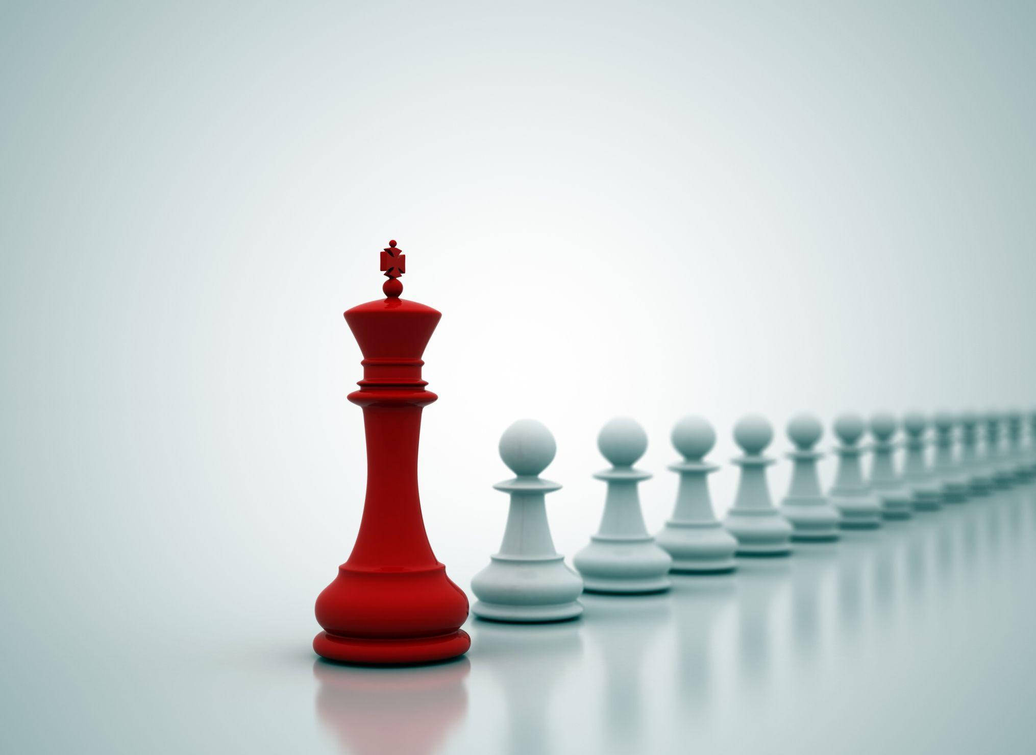 Teamwork 桌布 壁紙 — 一個大膽的紅色西洋棋國王獨自站在一排後退的白色兵卒前面，在極簡的反射表面上。