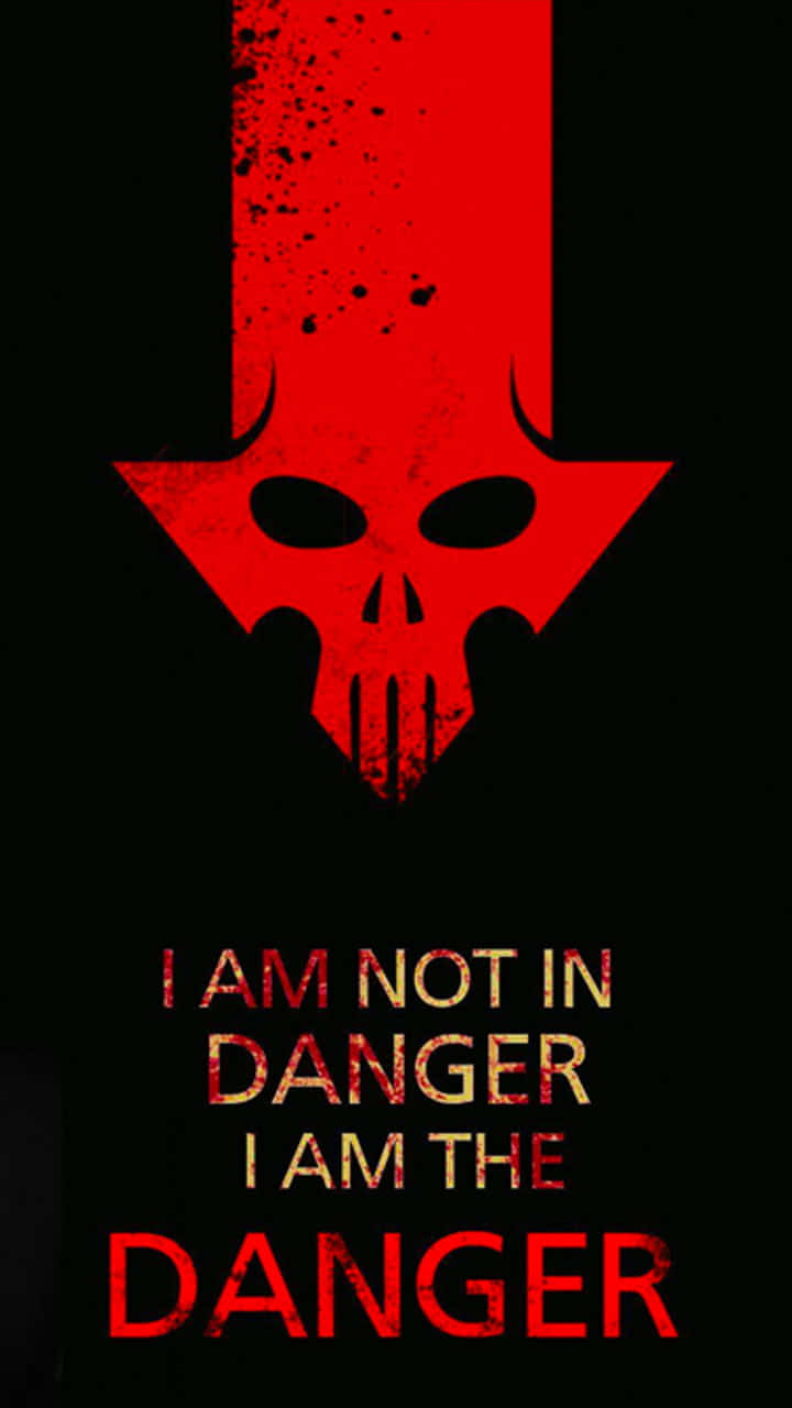 Danger 桌布 壁紙 — 一個大膽的紅色骷髏箭頭指向黑色背景，帶有粗糙紋理，並以磨損的紅色和金色寫上「我並非身處危險，我就是危險」的文字。