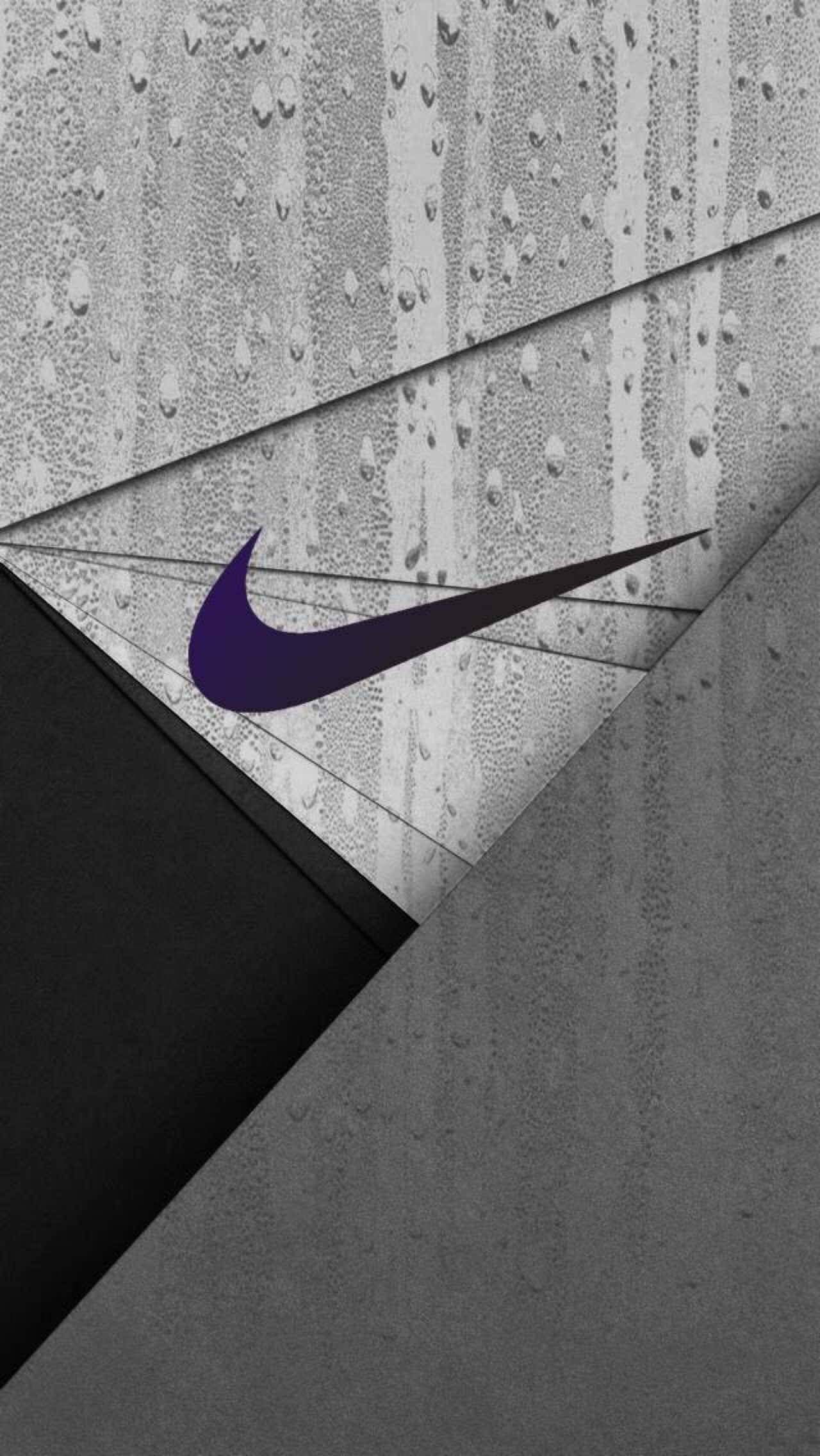 Cool Gray 桌布 壁紙 — 一個大膽的紫色Nike勾號在濕混凝土和雨滴的單色幾何背景上形成對比。