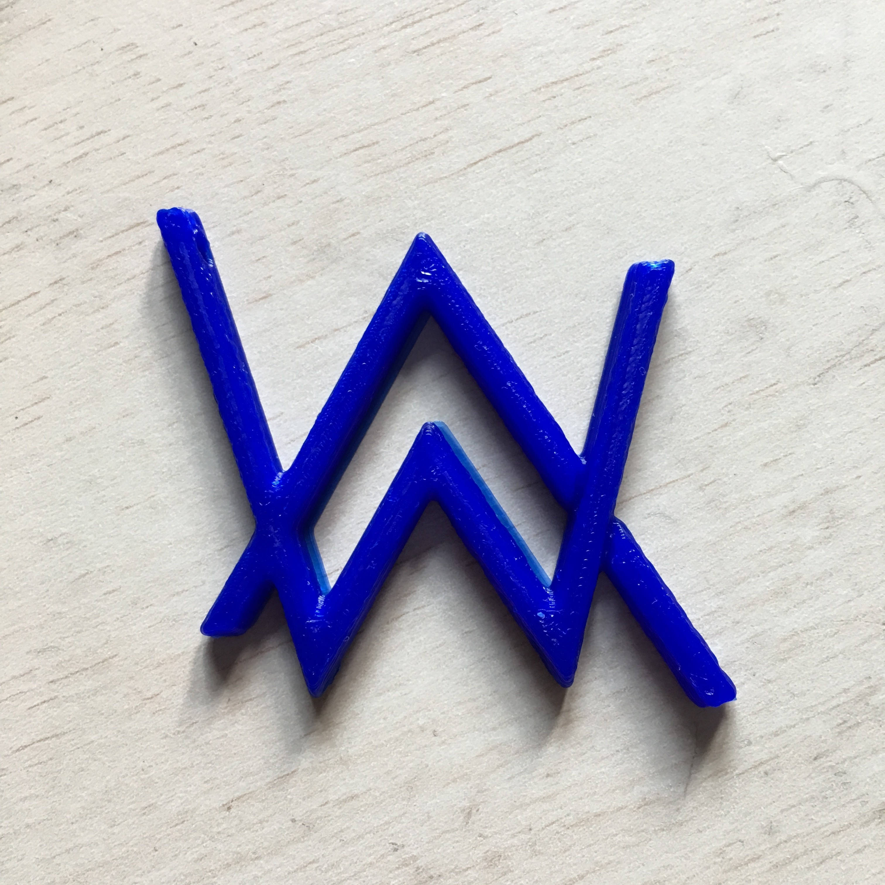 3D 桌布 壁紙 — 一個大膽的藍色3D列印「W」標誌放置在淺色木質表面上，木紋清晰可見。
