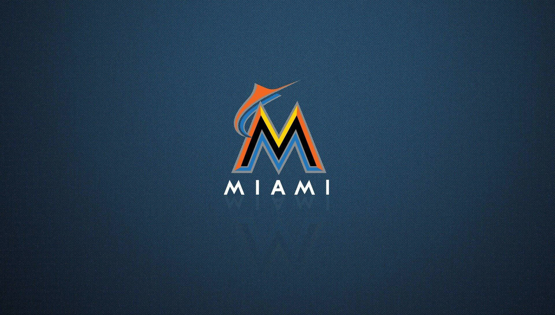 Marlins 桌布 壁紙 — 一個大膽的邁阿密標誌，帶有橙色、黃色和藍色點綴，居中在帶有紋理的深藍色背景上。