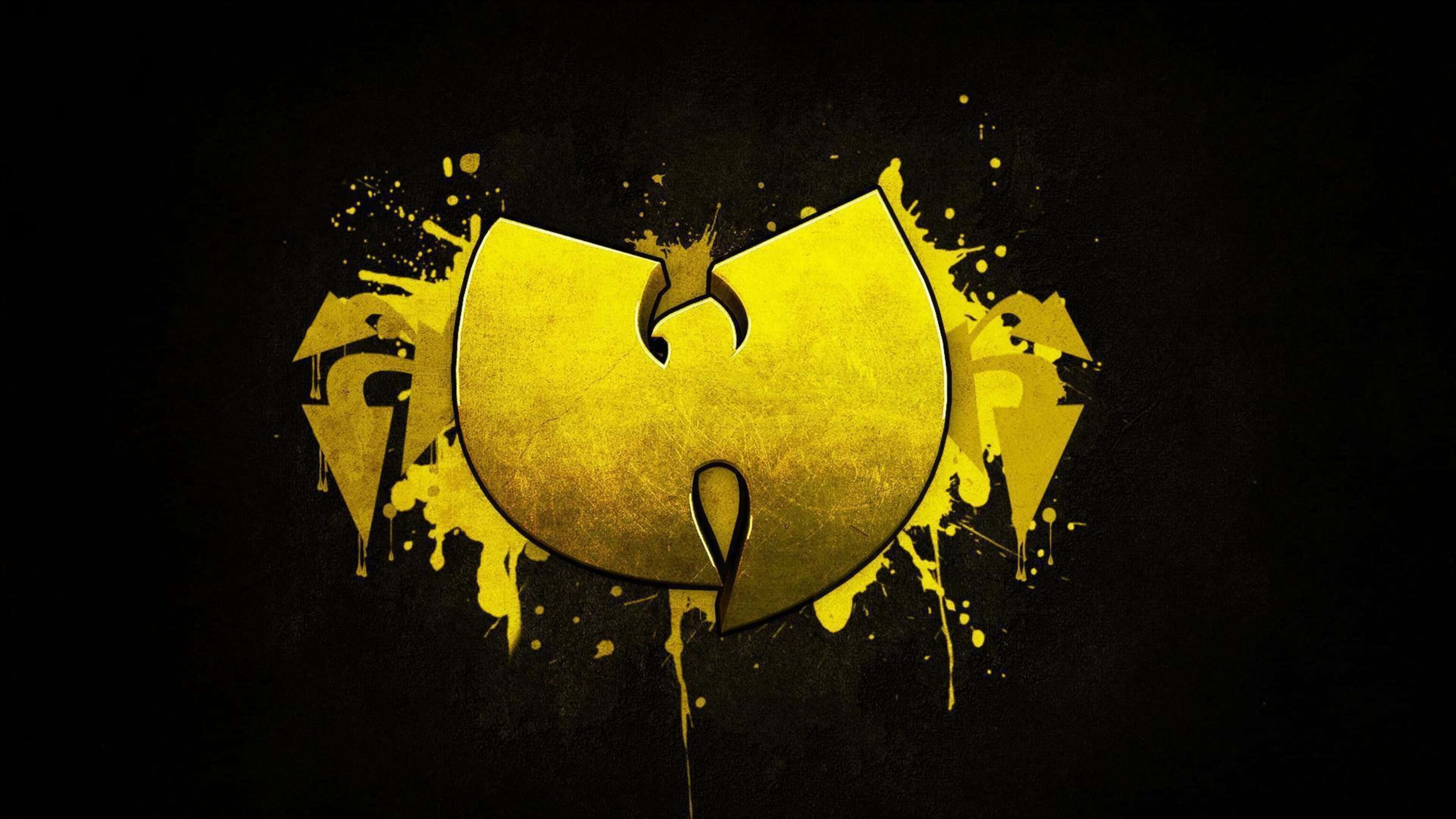 嘻哈 桌布 壁紙 — 一個大膽的金色Wu-Tang Clan標誌，在黑色背景上濺滿黃色油漆。