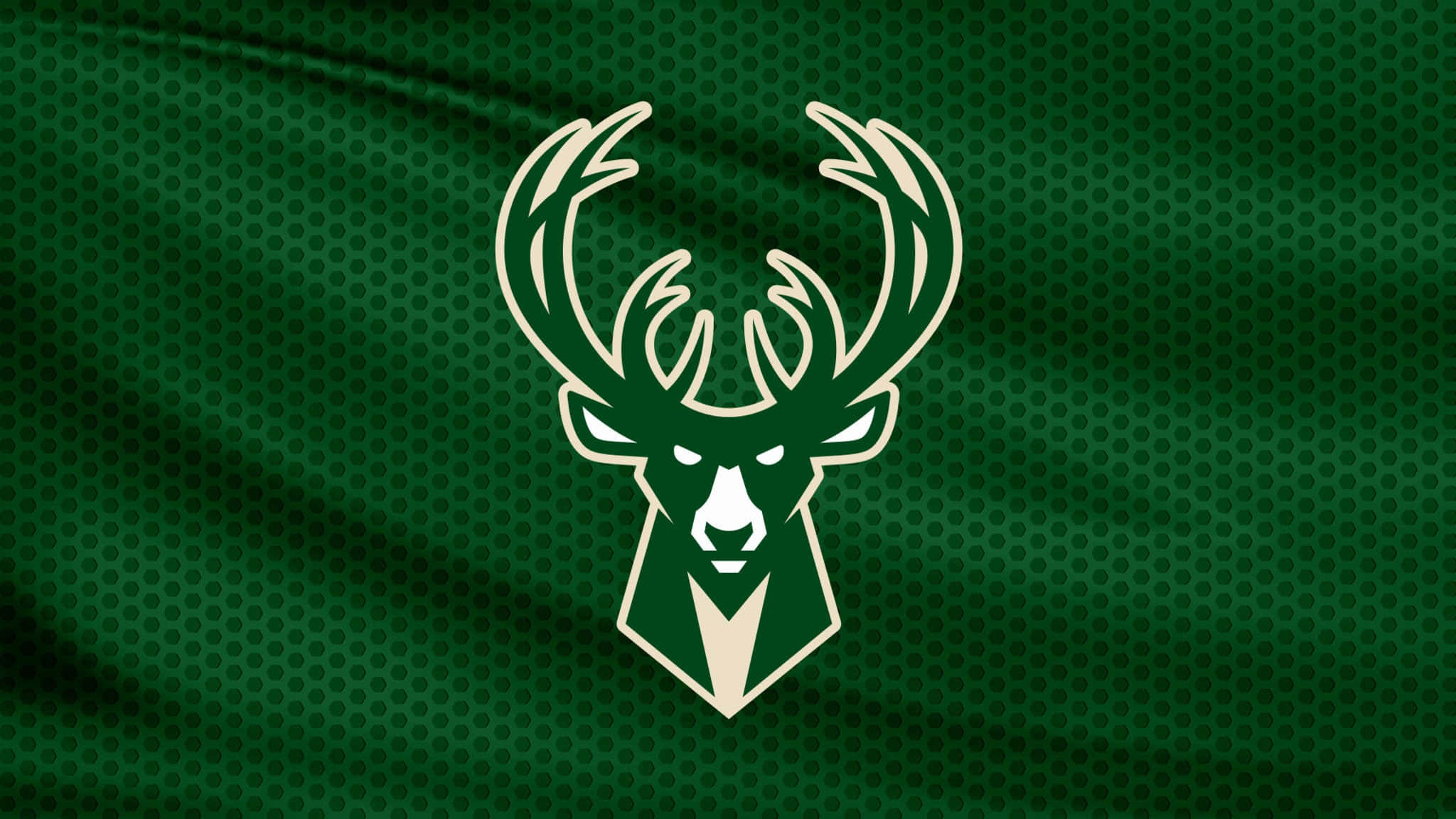 Bucks 桌布 壁紙 — 一個大膽的鹿頭標誌，以奶油色和綠色呈現，在帶有紋理的綠色織物背景上脫穎而出。