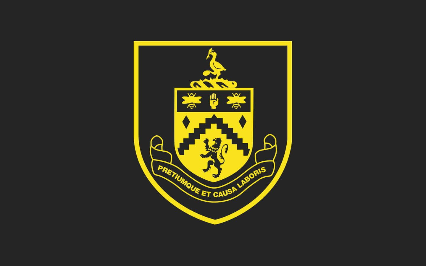 Burnley Fc 桌布 壁紙 — 一個大膽的黃色紋章，帶有獅子和格言，背景為黑色。