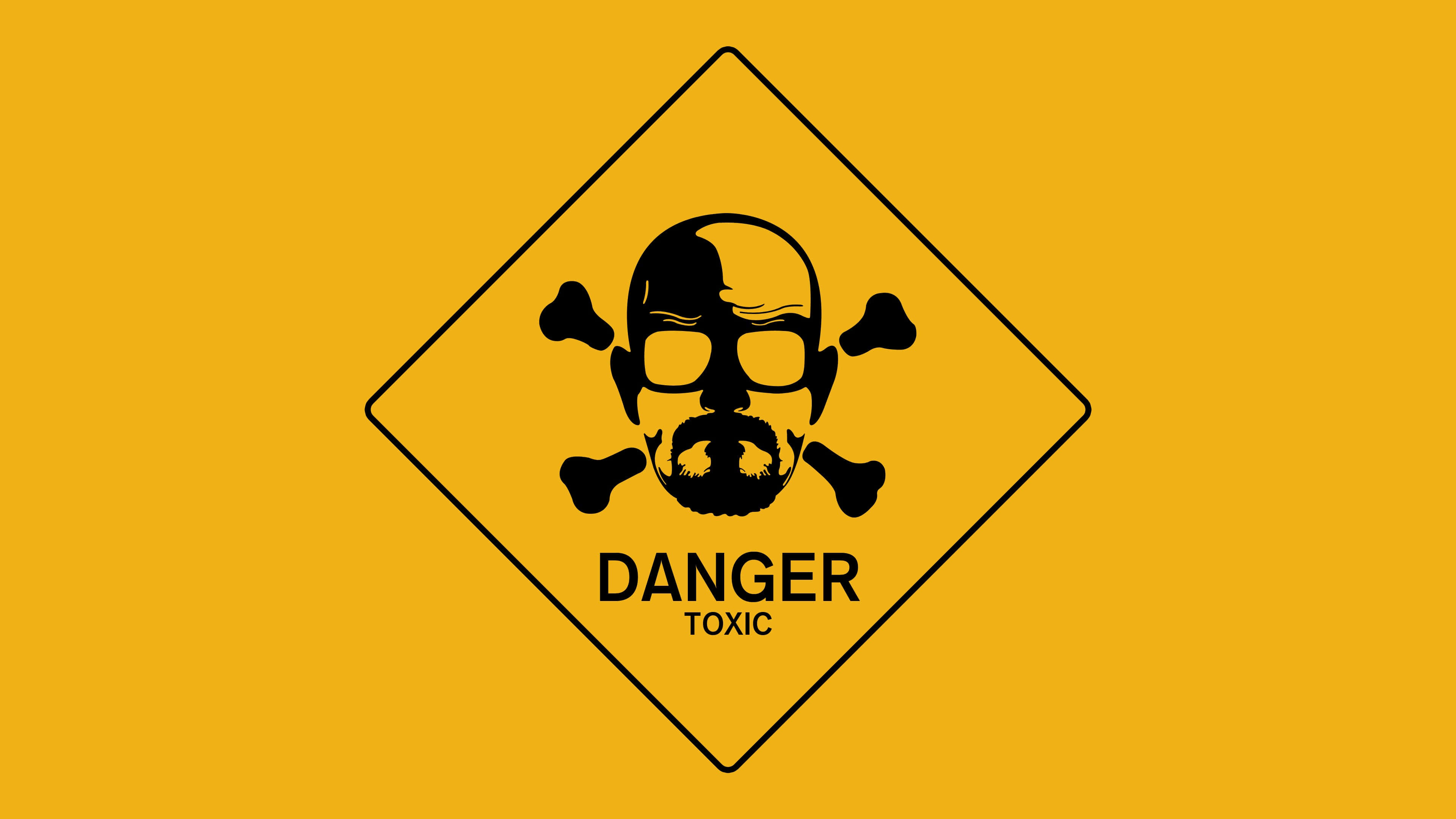 Warning Sign 桌布 壁紙 — 一個大膽的黃色菱形警告標誌，上面有一個戴眼鏡和鬍子的骷髏頭，下方是交叉骨頭，並有「DANGER TOXIC」文字。