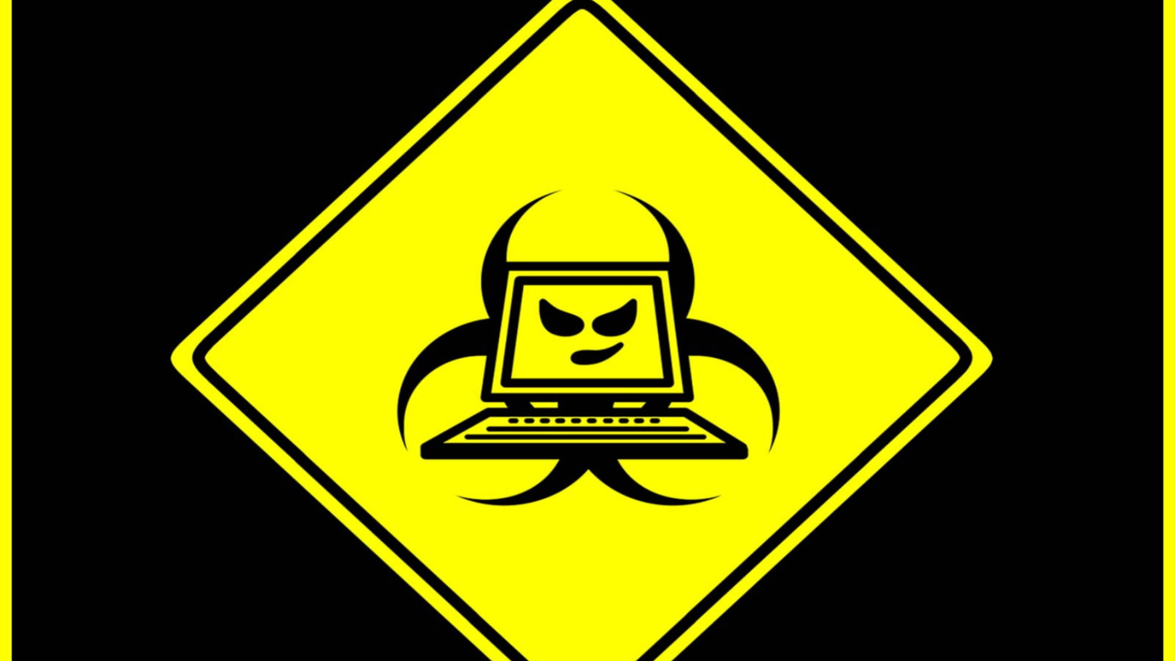 hacker desktop 桌布 壁紙 — 一個大膽的黃色菱形警告標誌，在黑色背景上顯示一個帶有憤怒表情的筆記型電腦疊加在生物危害符號上。