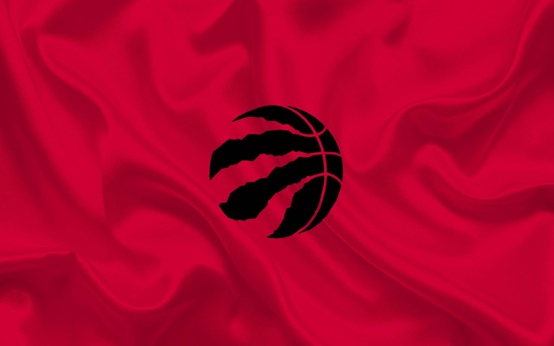 Raptors 桌布 壁紙 — 一個大膽的黑色多倫多暴龍隊標誌，置於豐富的紅色緞面布料上，帶有流動的褶皺和高光。