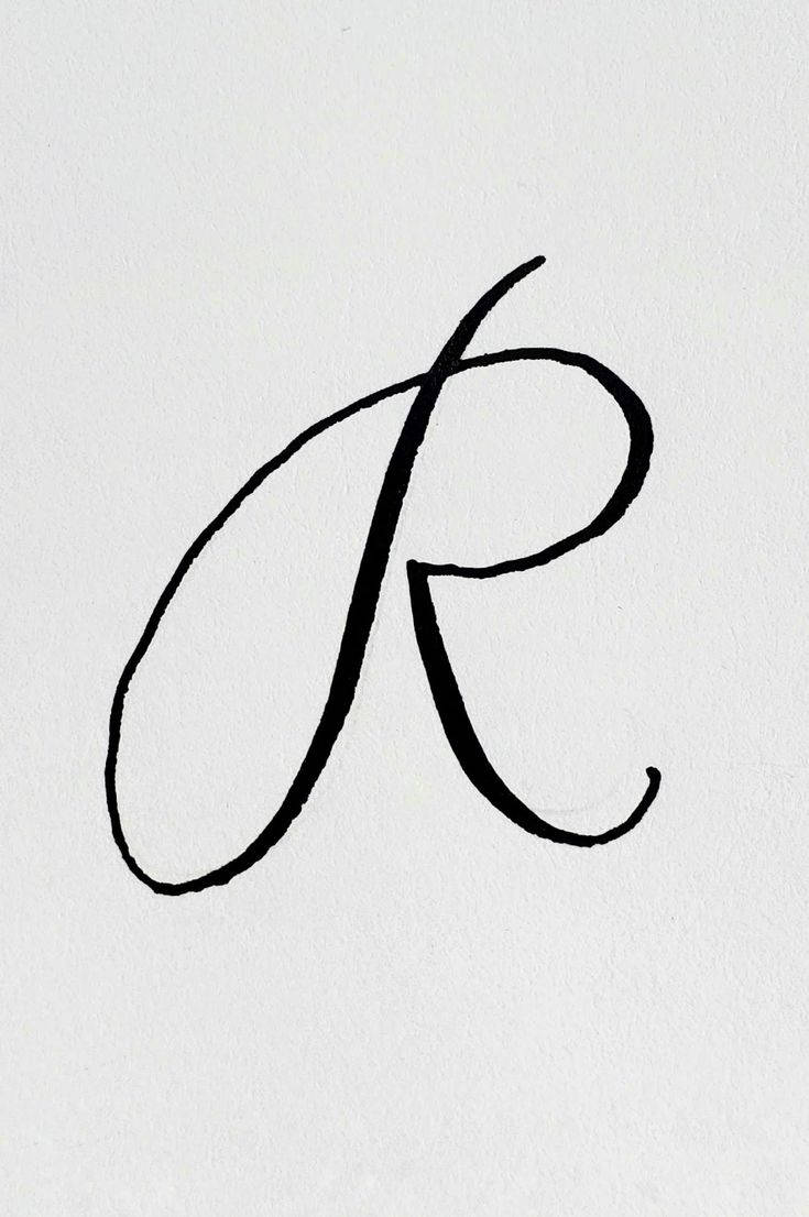 R 桌布 壁紙 — 一個大膽的黑色草書字母R，優雅地繪製在帶有可見墨跡的紋理白紙上。
