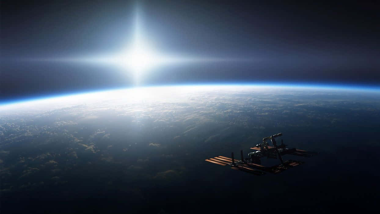 Earth Science 桌布 壁紙 — 一個太空站繞地球運行，太陽在行星彎曲的地平線上方明亮地照耀。