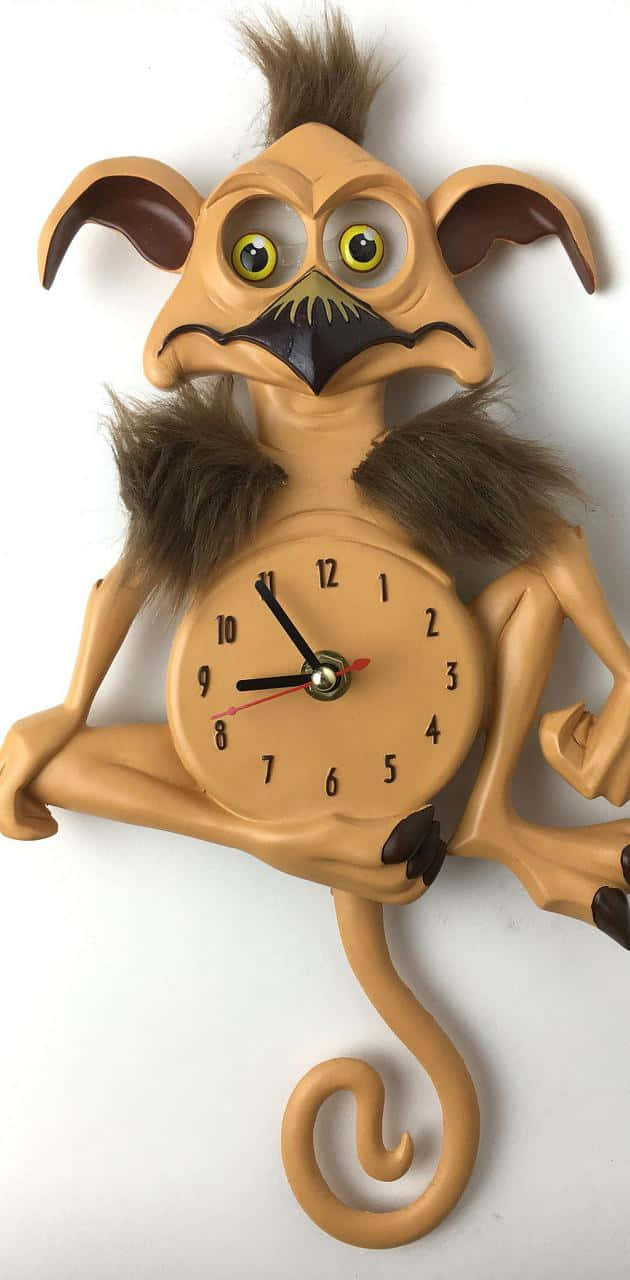 Clock 桌布 壁紙 — 一個奇特的棕褐色時鐘，形狀像毛茸茸的生物，有大大的黃色眼睛和一條長長的捲曲尾巴。