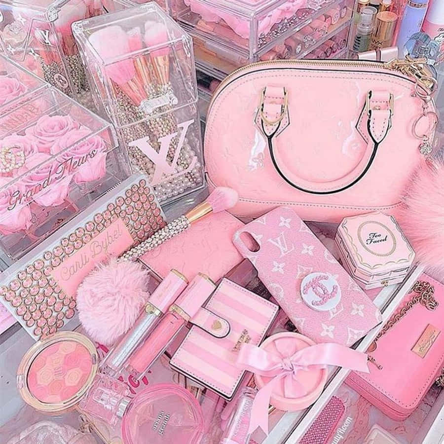 淺粉色調 桌布 壁紙 — 一個奢華的粉紅色美容系列，包含路易威登和香奈兒品牌物品，整齊地排列在透明壓克力收納盒中。
