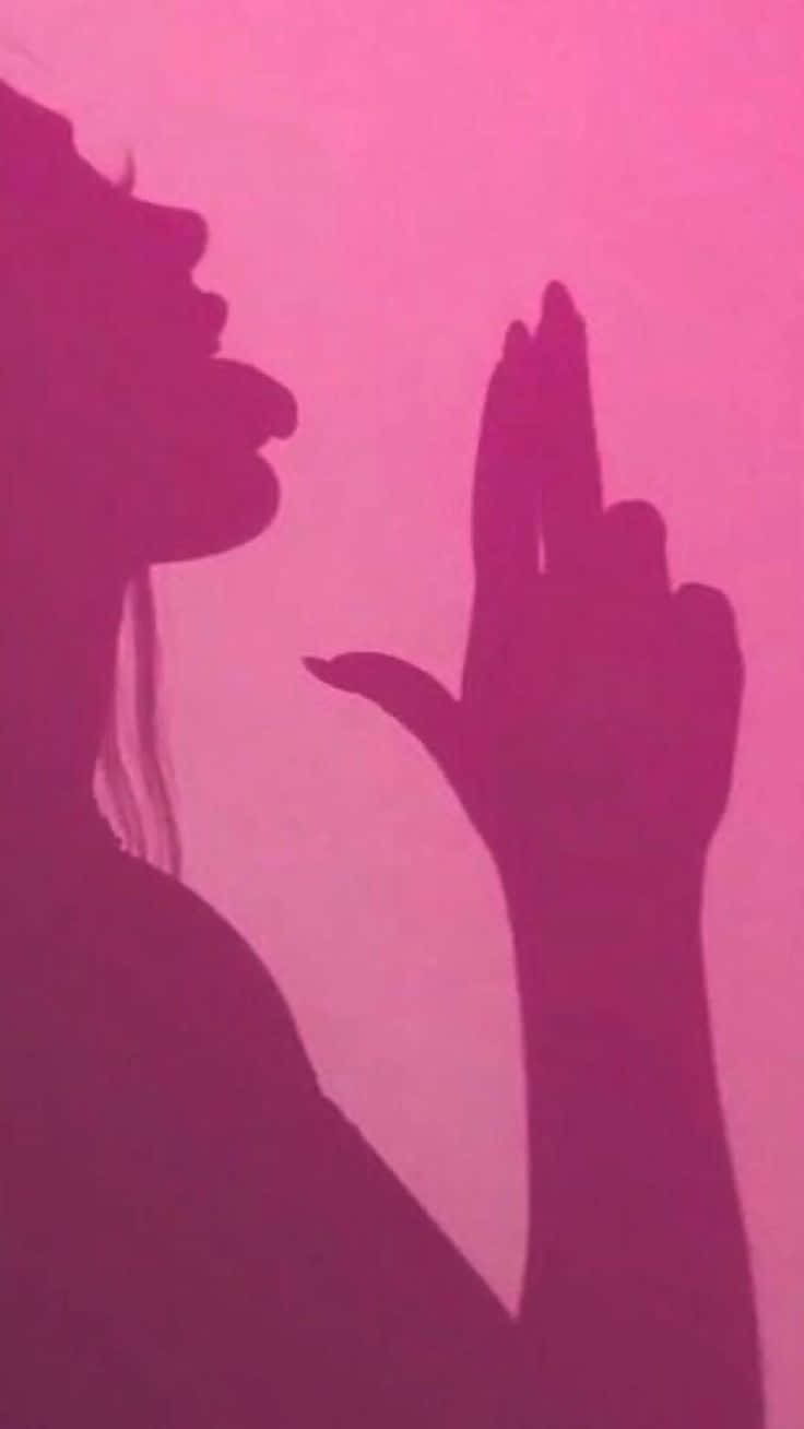 桌布 壁紙 — 一個女人側面輪廓，手舉起做手勢，背景是充滿活力的粉紅色。