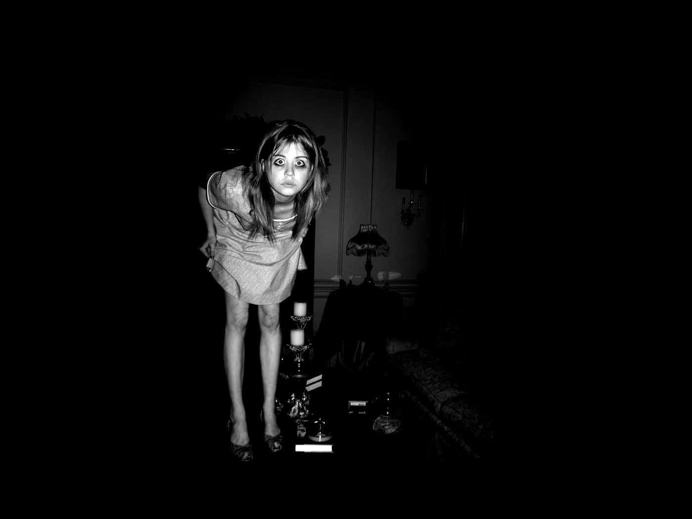 燭光照亮的黑暗房間裡，女人露出驚恐的表情。 — 詭異的GIF 壁紙