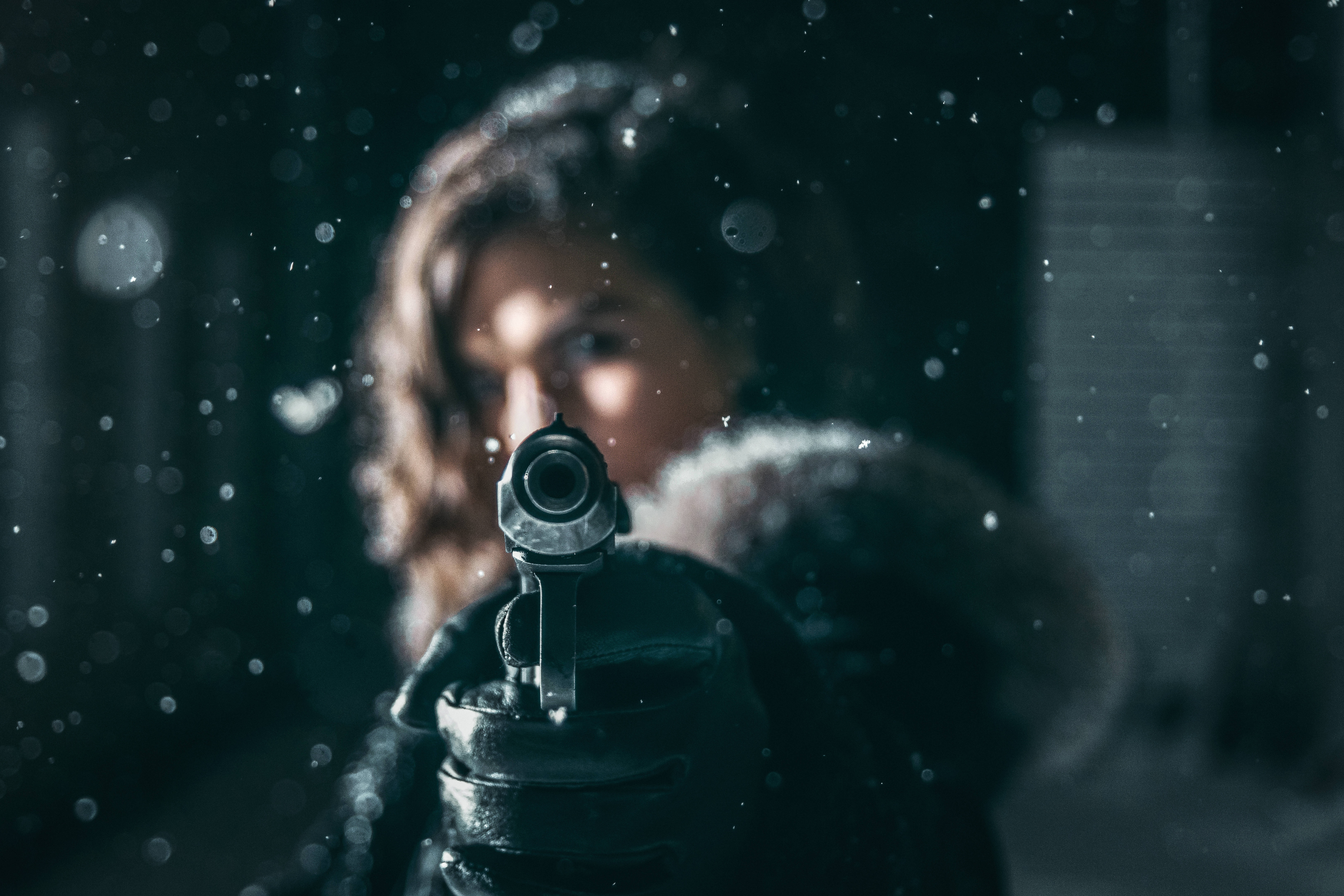 槍枝 桌布 壁紙 — 一個女人在雪夜中手持手槍，專注地指向觀眾。