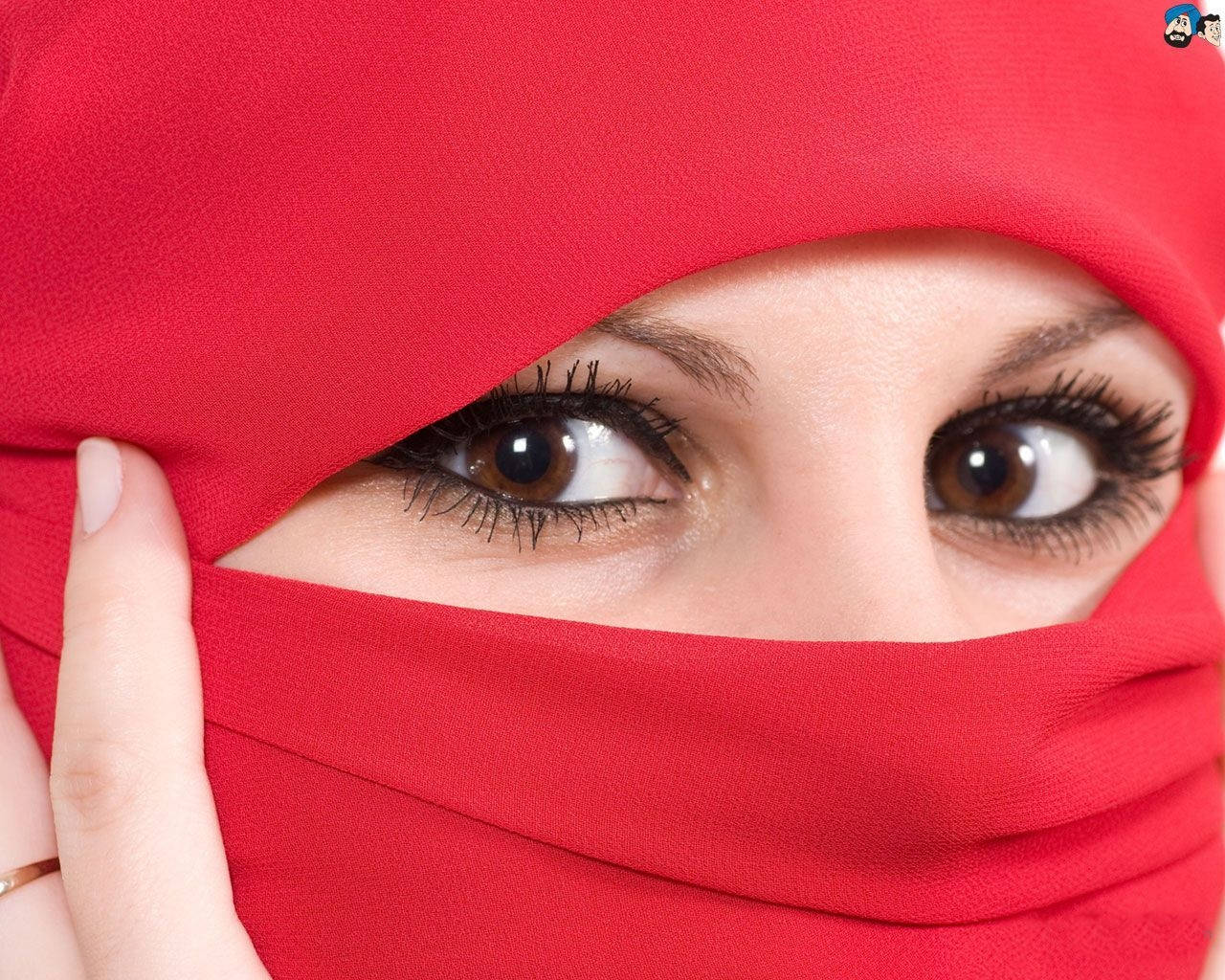 muslim 桌布 壁紙 — 一個女人強烈的棕色眼睛透過鮮紅色頭巾窺視的特寫，一隻手輕輕調整布料。