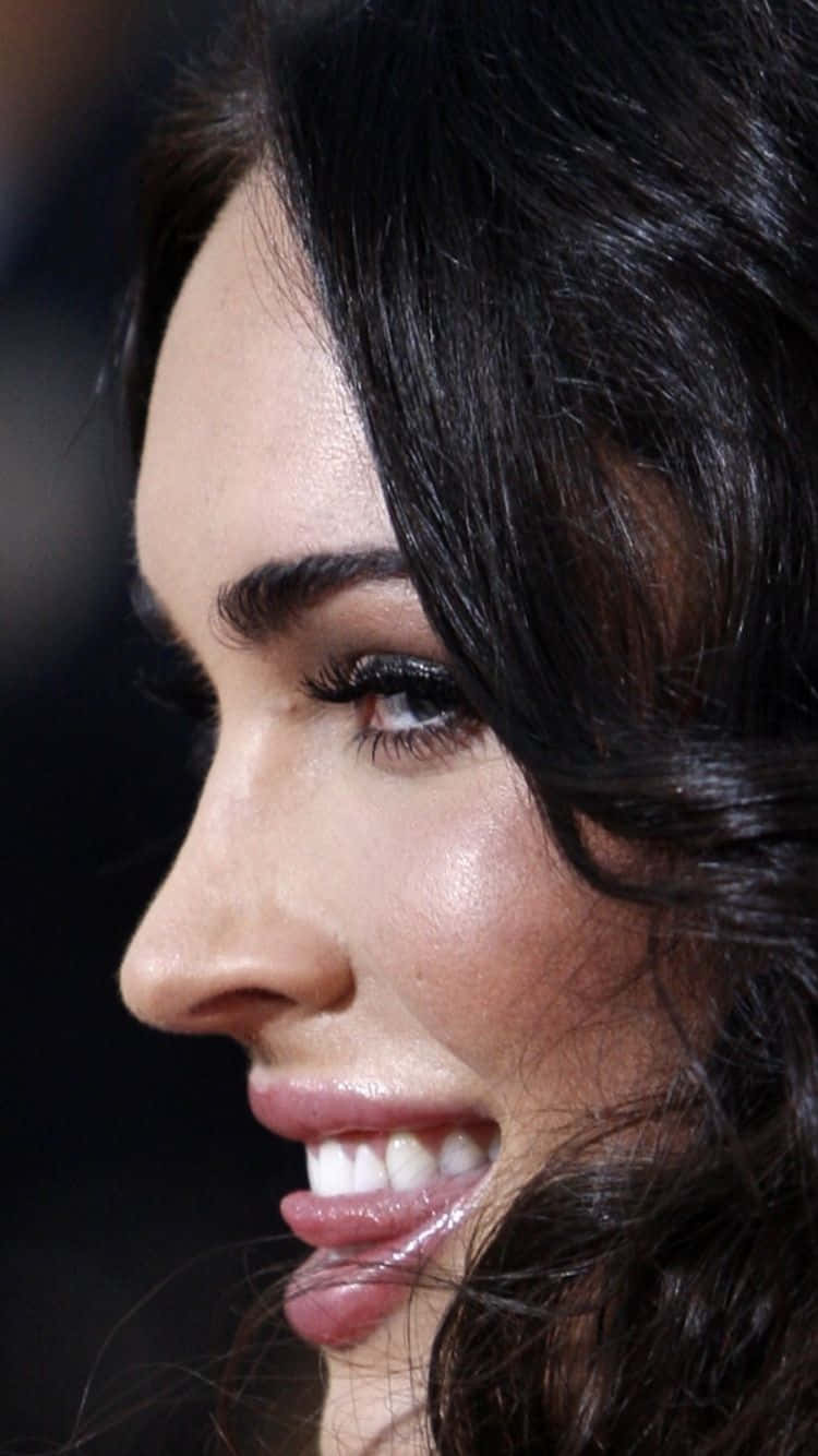 Celebrity 桌布 壁紙 — 一個女人微笑的臉部特寫，深色波浪頭髮和明亮的眼睛，背景模糊。
