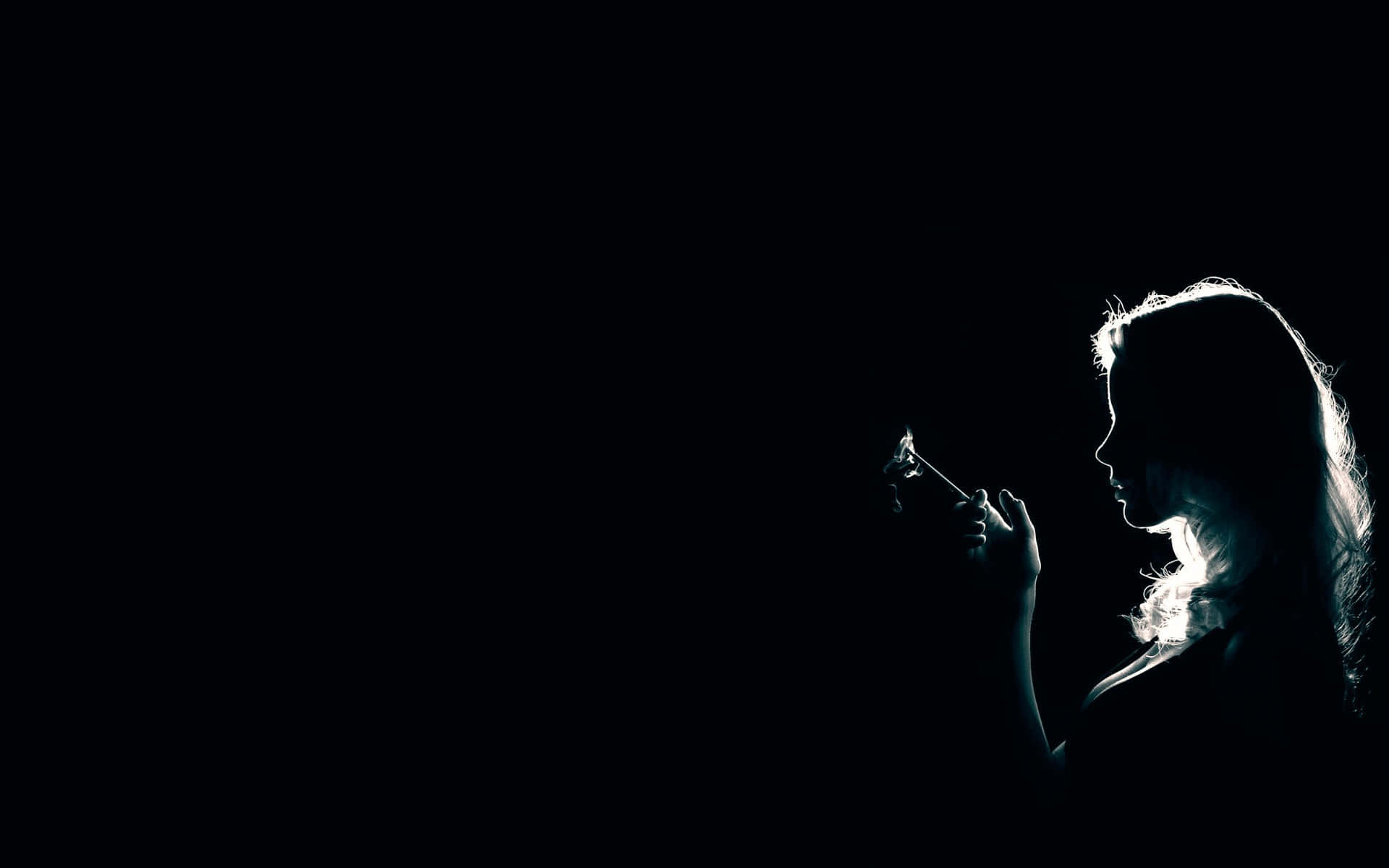 darkness 桌布 壁紙 — 一個女人的剪影在鮮明的黑白對比中，手持點燃的香煙對著虛空，她的側面輪廓在背光中閃耀。