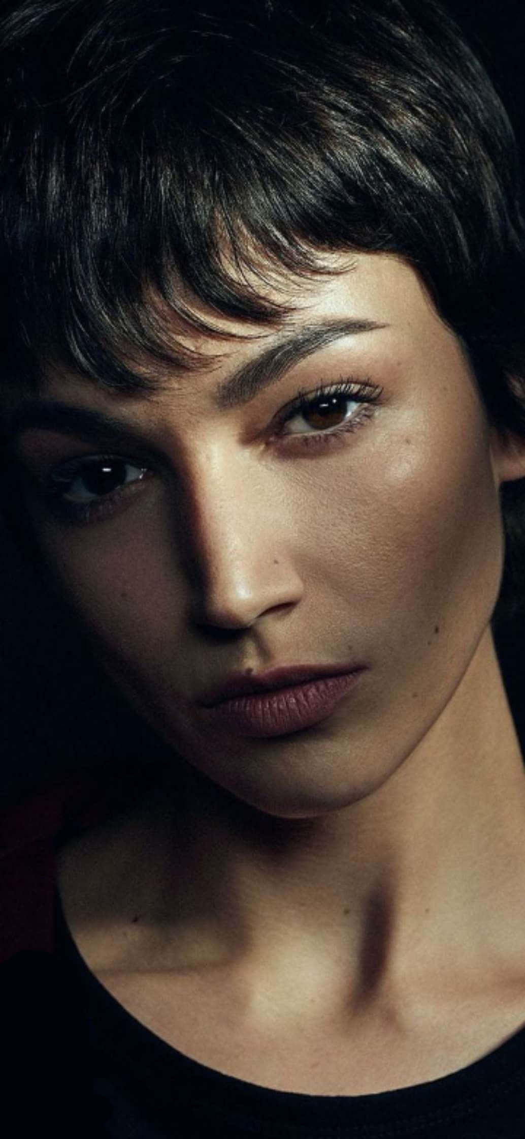 Beautiful Woman 桌布 壁紙 — 一個女人的特寫肖像，短黑髮和強烈的眼神，背景是黑色。