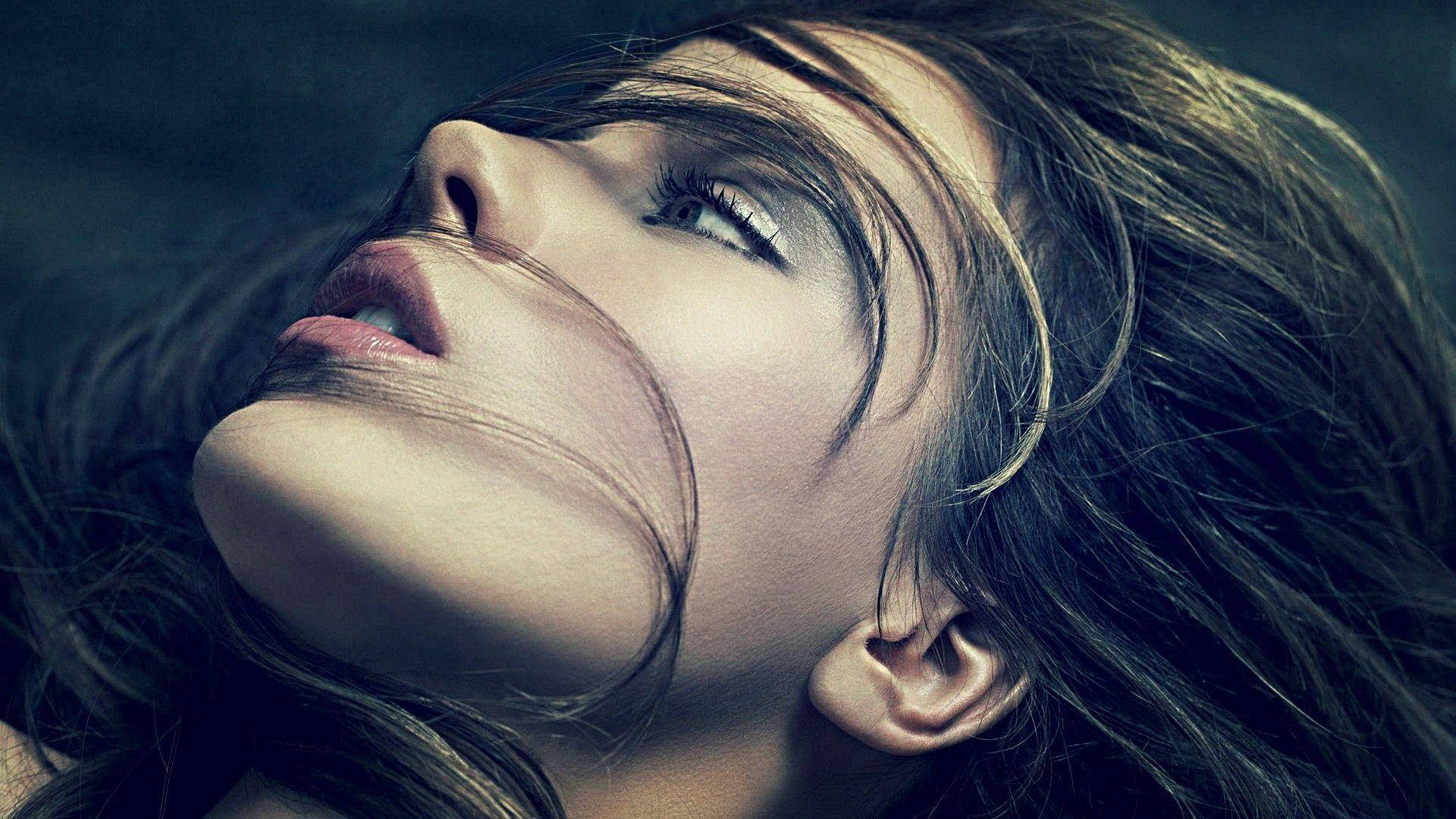 Kate Beckinsale 桌布 壁紙 — 一個女人的臉向上傾斜，頭髮被風吹起，柔和的光線突顯她平靜的表情。