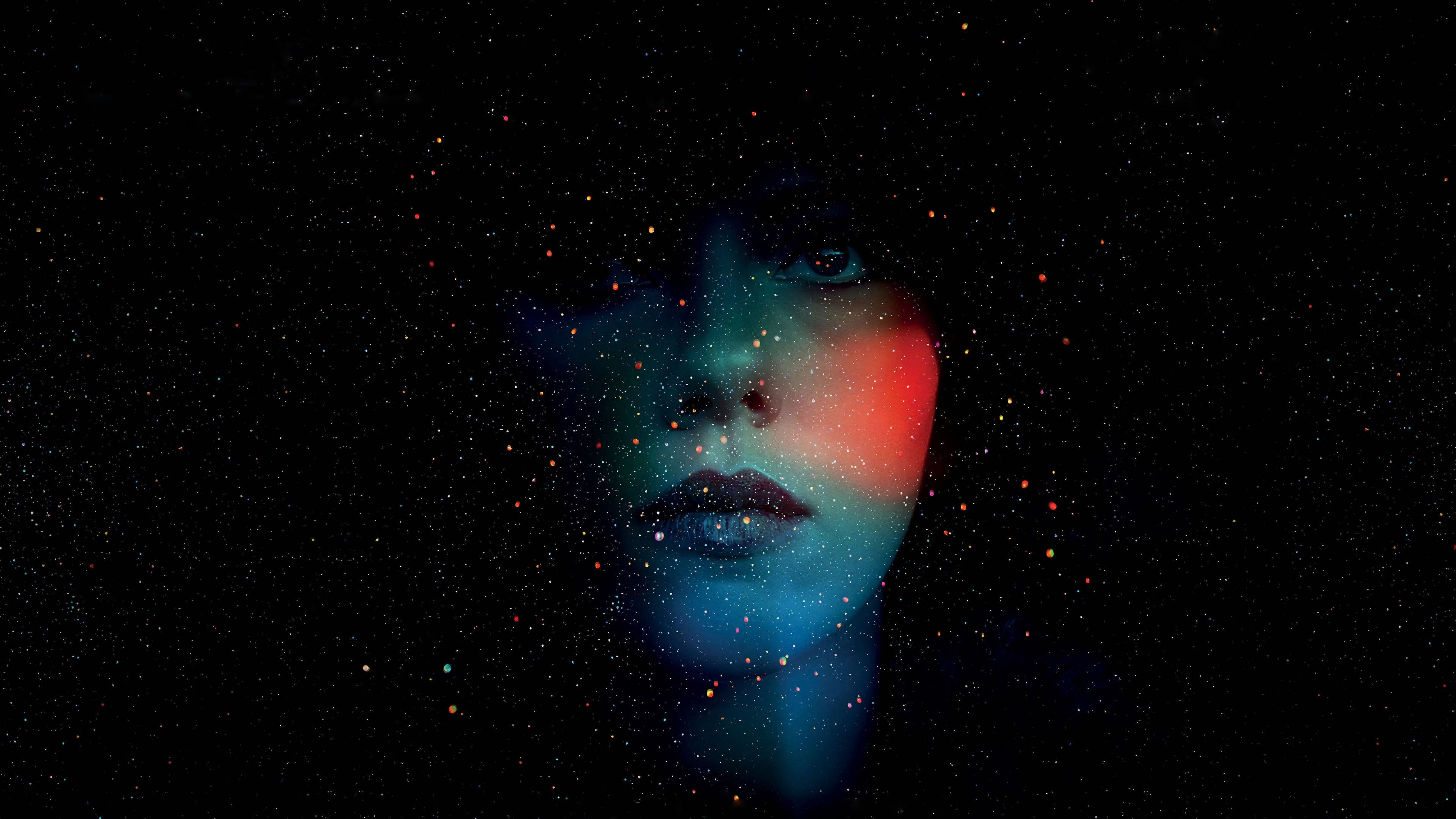 Face 桌布 壁紙 — 一個女人的臉從宇宙黑暗中浮現，藍色和紅色的星光閃耀，照亮了她的五官。