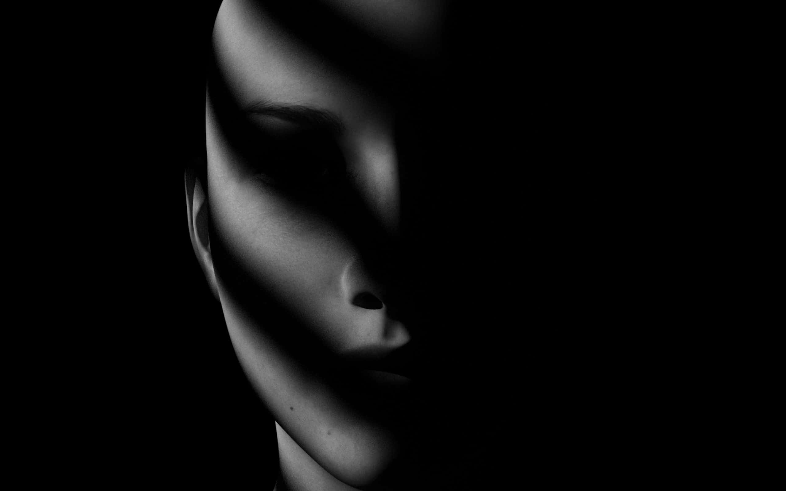 macabre 桌布 壁紙 — 一個女人的臉部在黑色背景上被戲劇性的陰影部分照亮。